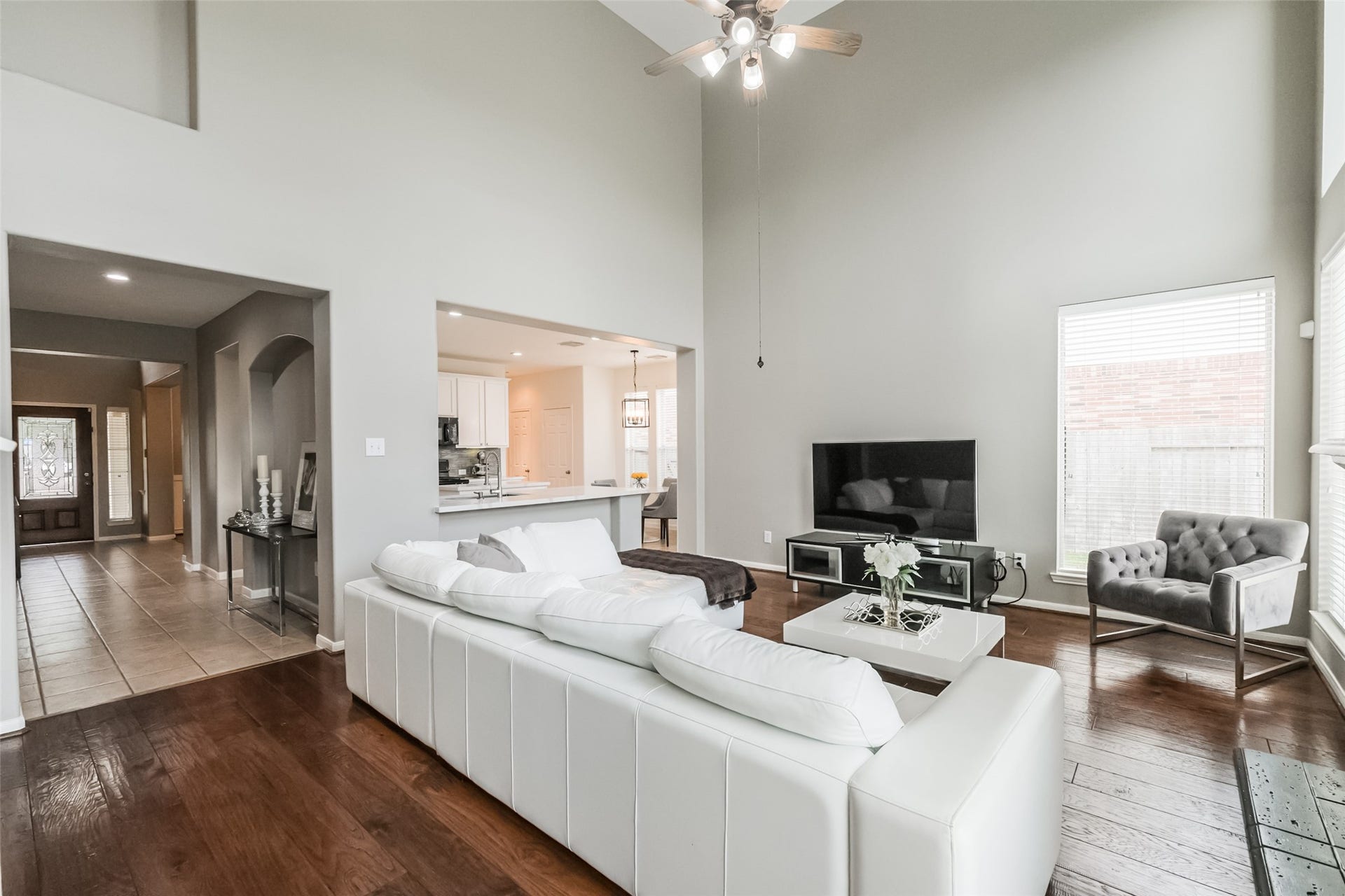 10314 Five Oaks Crossing, Missouri City, TX 77459 Spacious living area with high ceilings, hardwood floors, and abundant natural light. The open layout connects to the kitchen, featuring modern fixtures and straight sight lines.