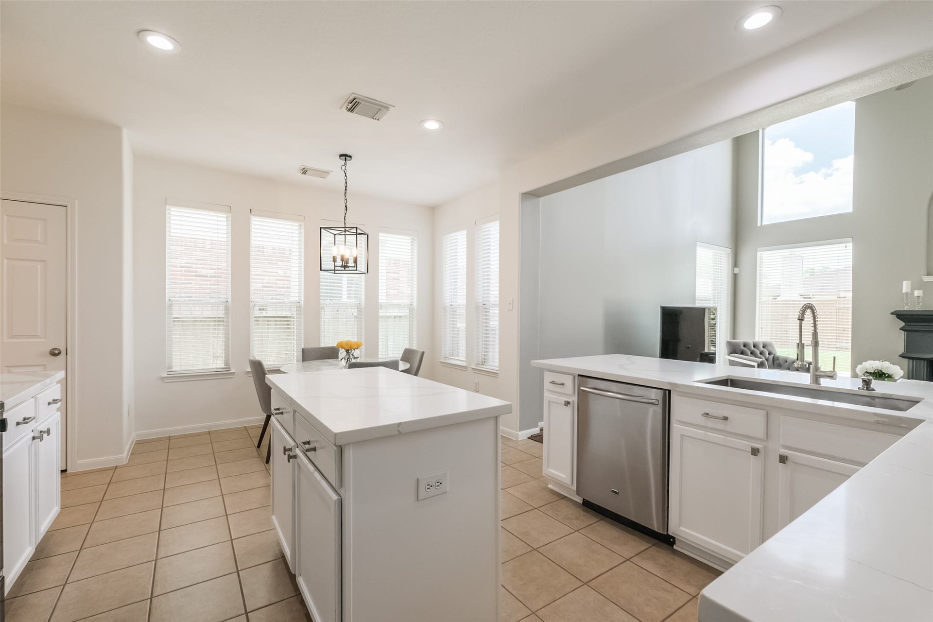 10314 Five Oaks Crossing, Missouri City, TX 77459 Bright and spacious kitchen with modern white cabinetry, a central island, stainless steel appliances, and large windows providing ample natural light.