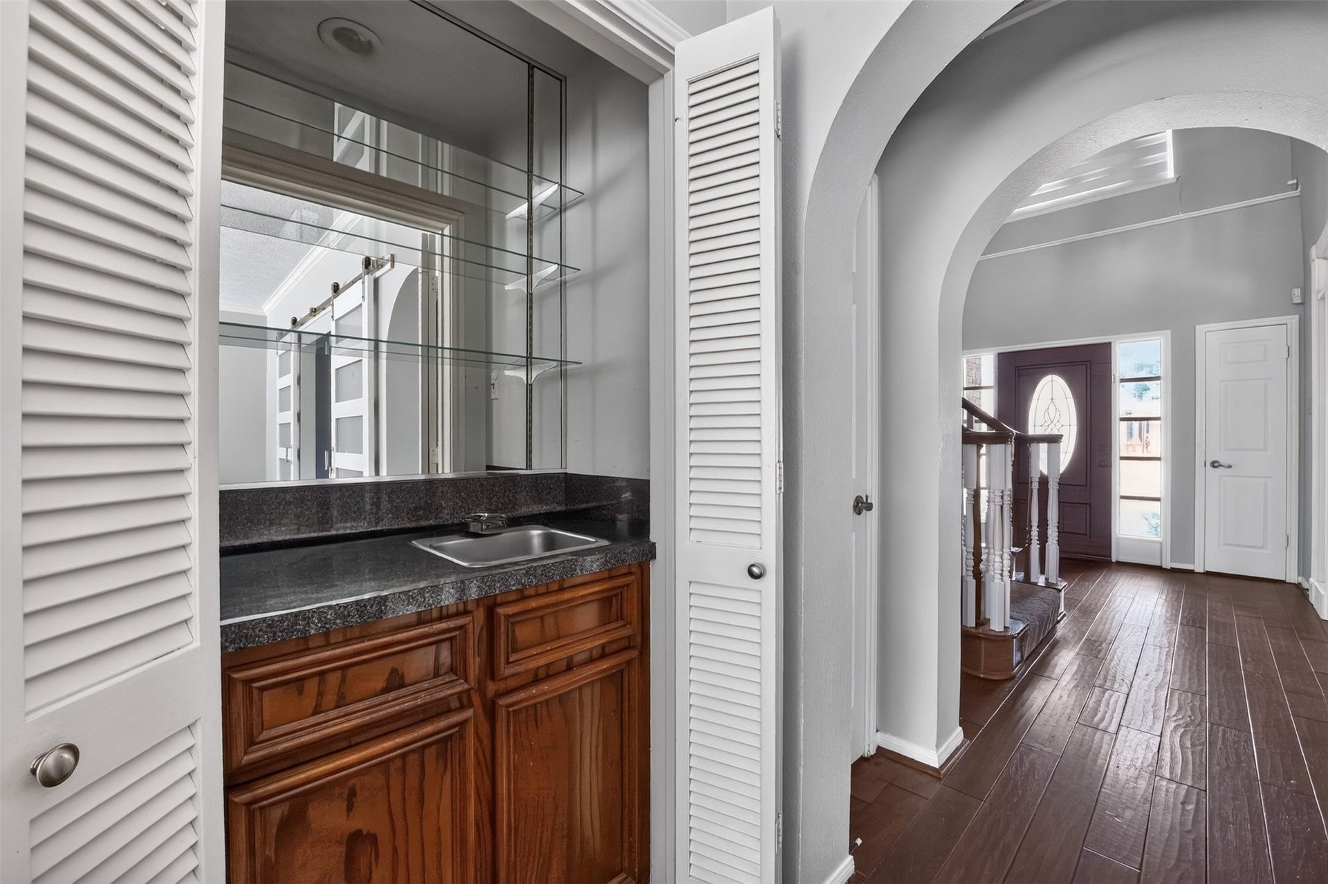 Wet bar hidden behind folding doors has room for all of your barware.