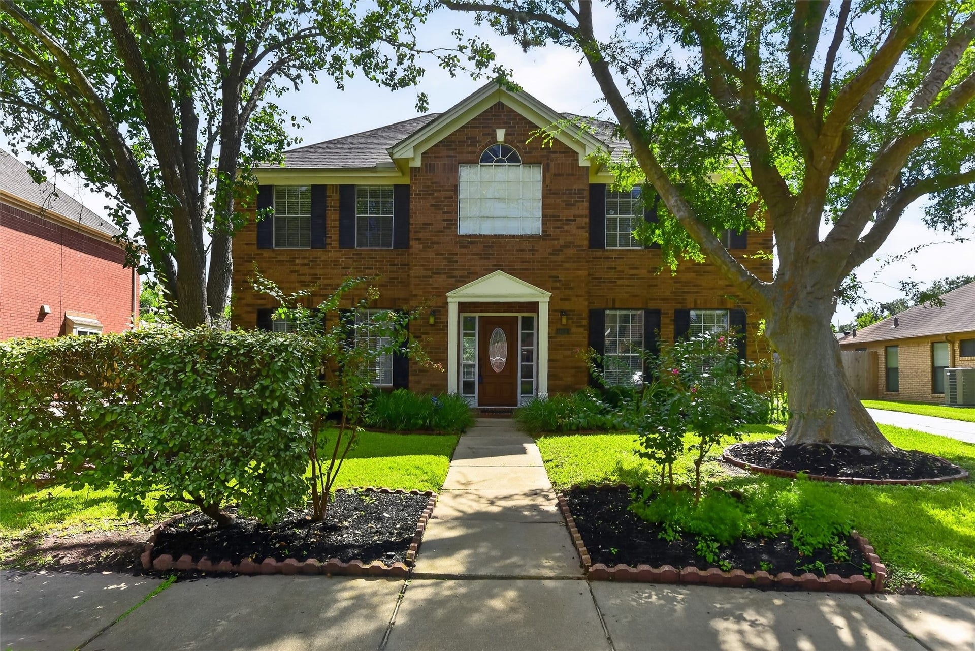 Your new home greets you with stately trees and lush landscaping.