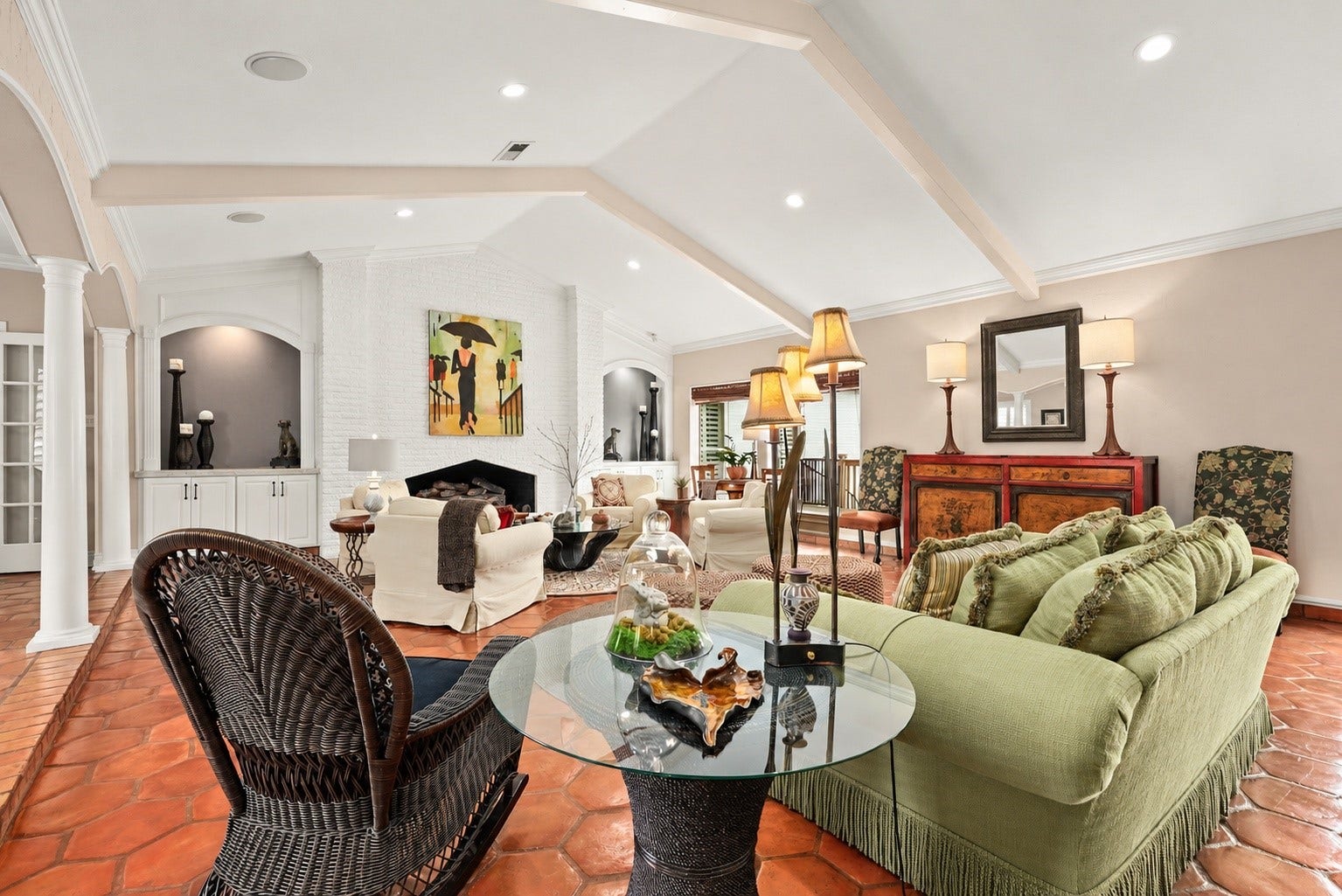 18607 Point Lookout Drive, Nassau Bay, TX 77058 Beautiful architectural details take center stage with a striking brick fireplace, custom built-in cabinetry, graceful arched niches, and elegant columns. The vaulted beamed ceiling and thoughtfully designed seating areas add warmth and character to this exceptional living space.
