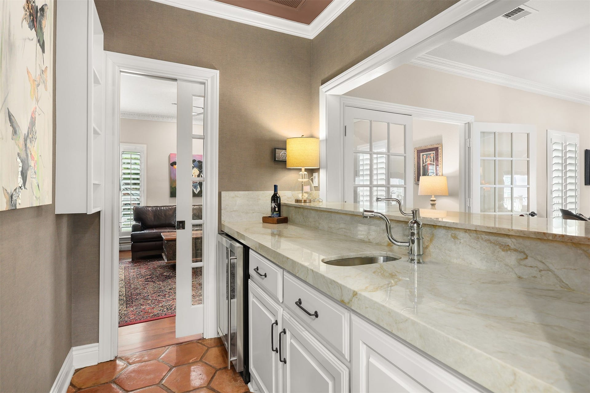 18607 Point Lookout Drive, Nassau Bay, TX 77058 View from the kitchen into the wet bar, featuring a charming French-style pocket door that can be closed for privacy or left open for easy access to the television room.