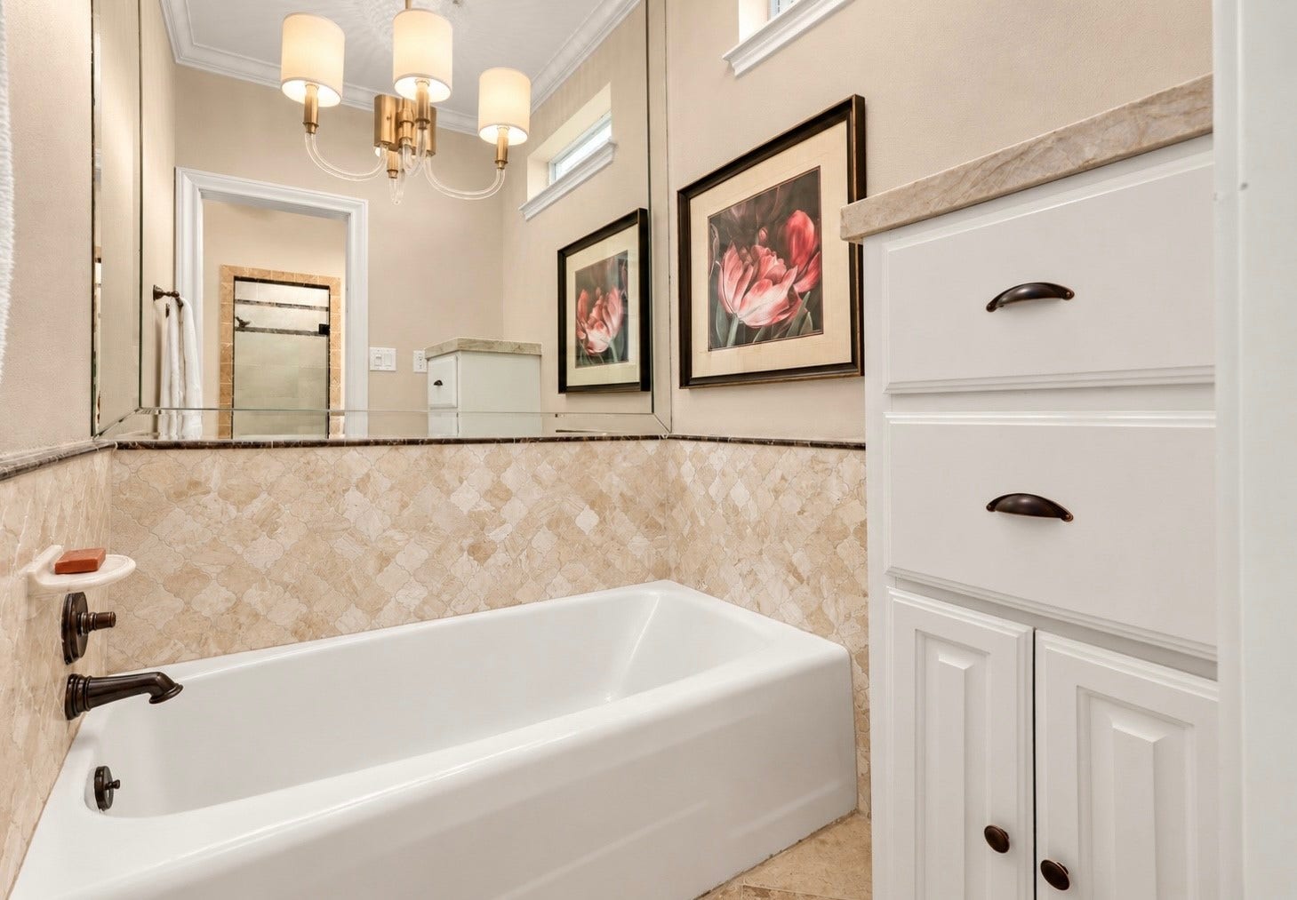 18607 Point Lookout Drive, Nassau Bay, TX 77058 Private soaking tub area features beautiful travertine tile with elegant marble trim and a large, beveled mirror. Custom cabinetry includes a convenient pull-out dry-cleaning hamper.