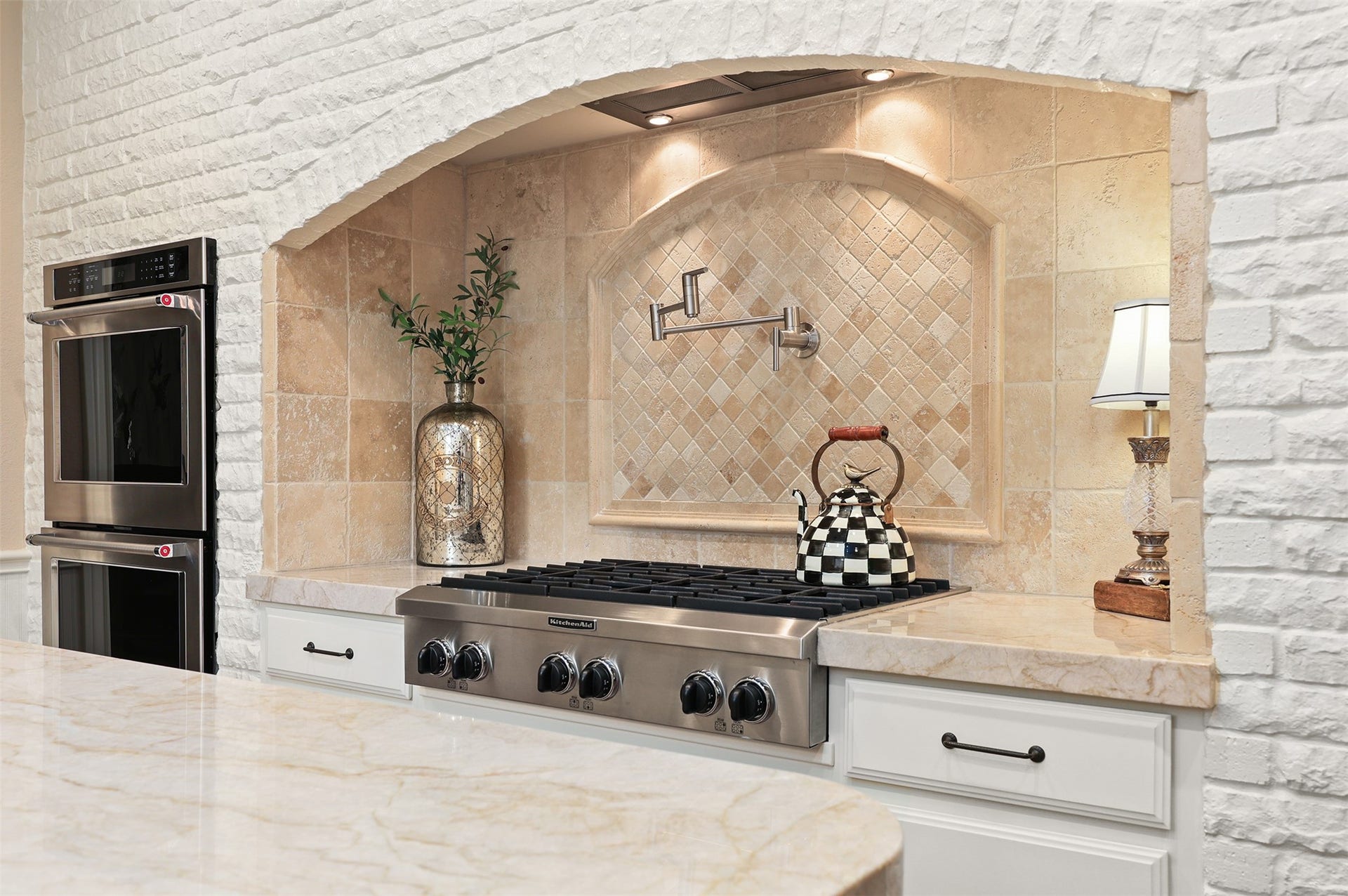 18607 Point Lookout Drive, Nassau Bay, TX 77058 A closer look at the impressive six-burner gas range, framed by a beautiful European-inspired brick archway with custom tilework and a convenient pot filler. Two built-in wall ovens complete this thoughtfully designed cooking space.