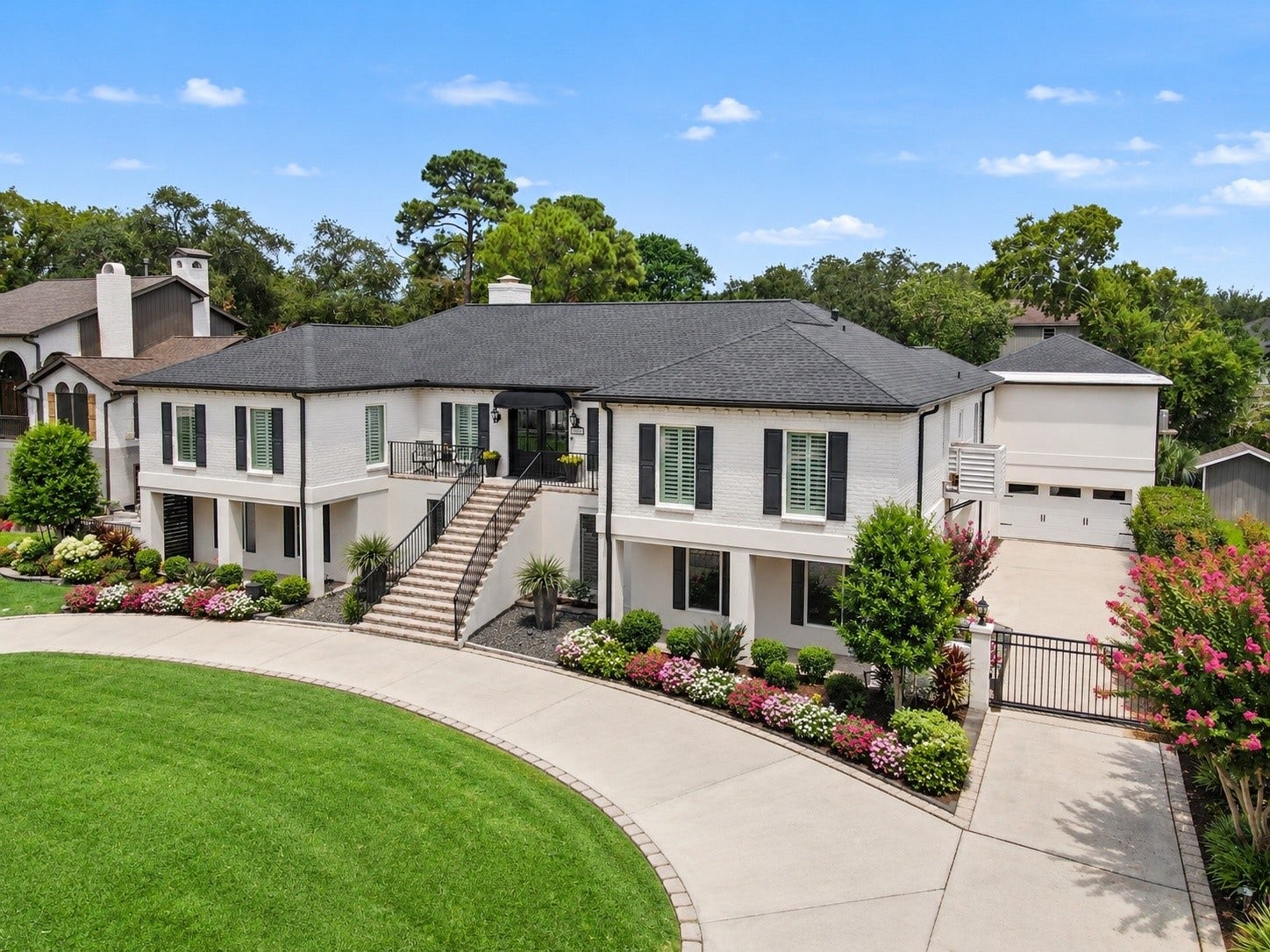 18607 Point Lookout Drive, Nassau Bay, TX 77058 Beautifully maintained grounds with lush landscaping and a nine-zone sprinkler system. An electric driveway gate provides added privacy and convenient access to the expansive driveway, garae, and additional covered parking beneath the home. Thoughtfully designed for both beauty and functionality.