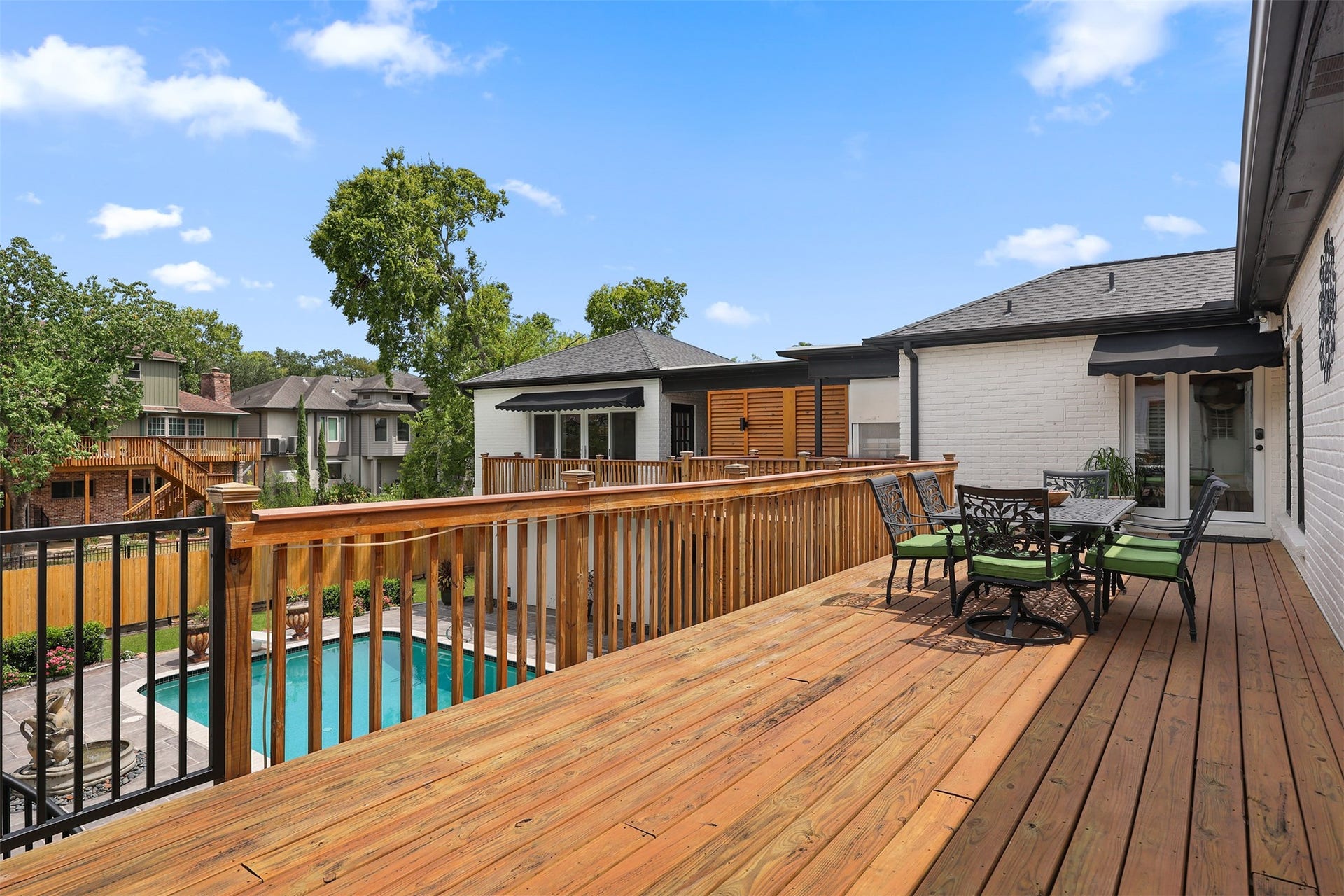 18607 Point Lookout Drive, Nassau Bay, TX 77058 Spacious elevated deck with convenient access from both the kitchen and hallway near the primary suite. Overlooking the sparkling pool and backyard, this inviting outdoor living space is perfect for dining, relaxing, and entertaining. A charming spiral staircase provides direct access to the pool area below.