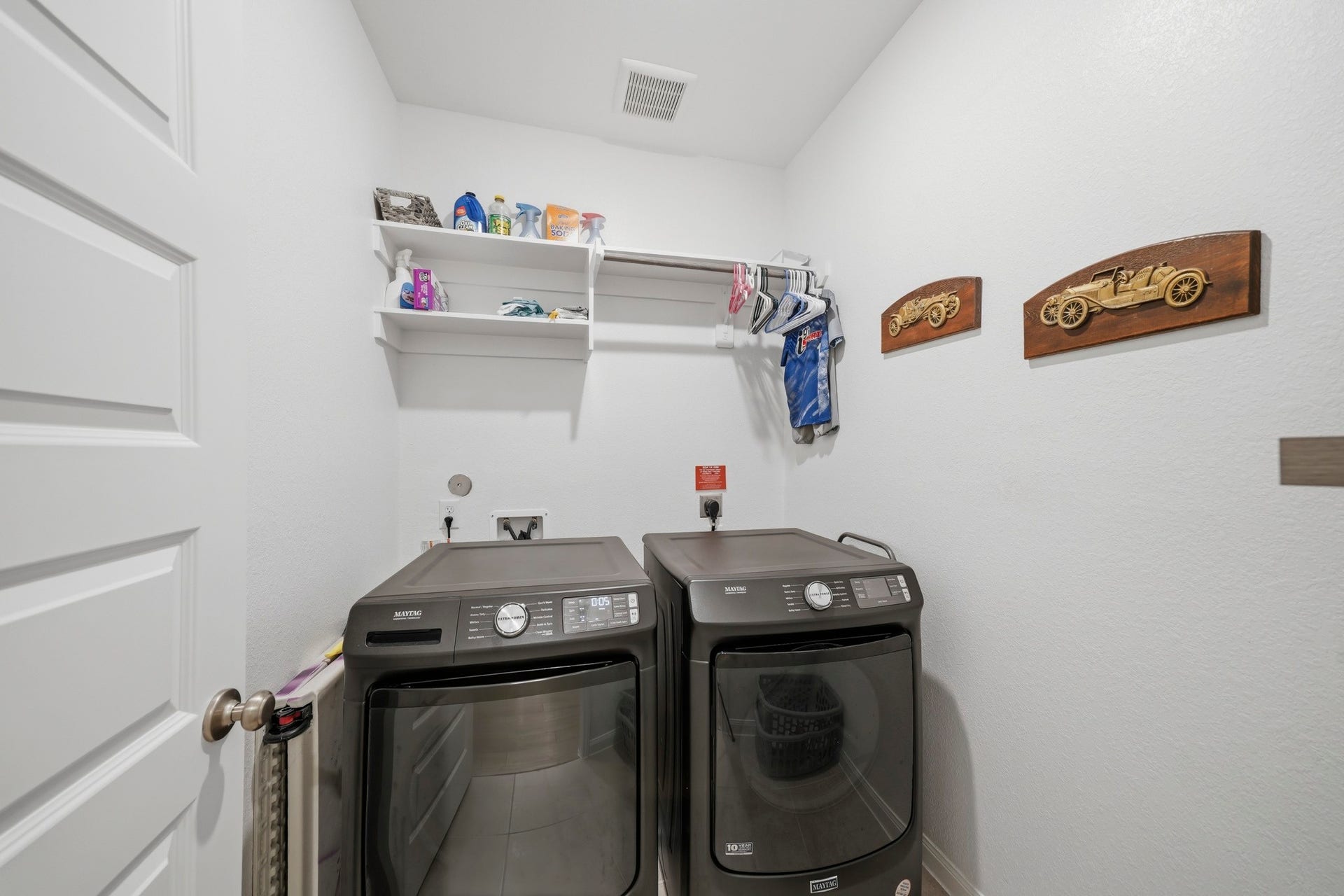 Modern laundry room with ample shelving and hanging space for convenience.