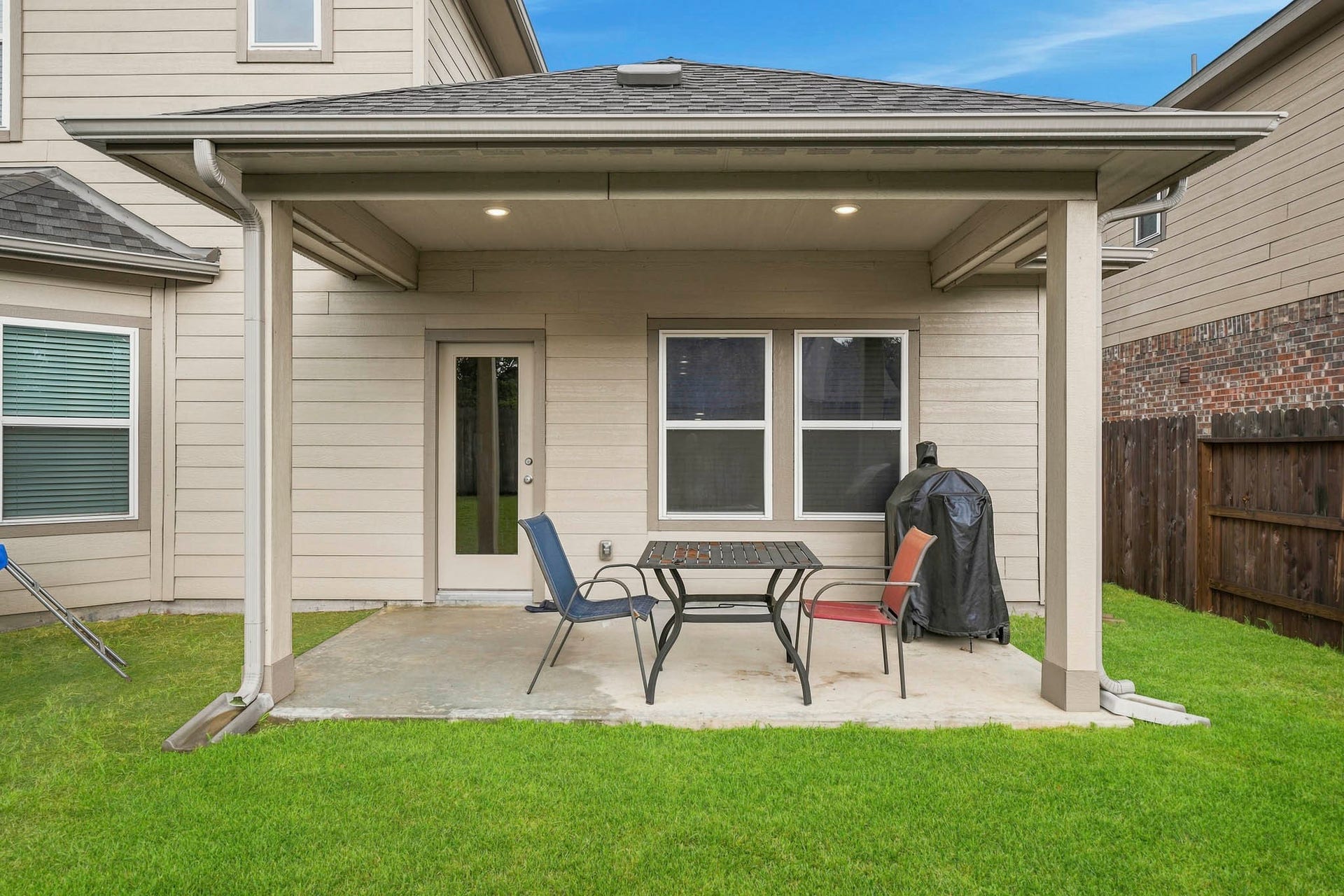 Charming covered patio with ample seating space, perfect for outdoor entertaining and relaxation.