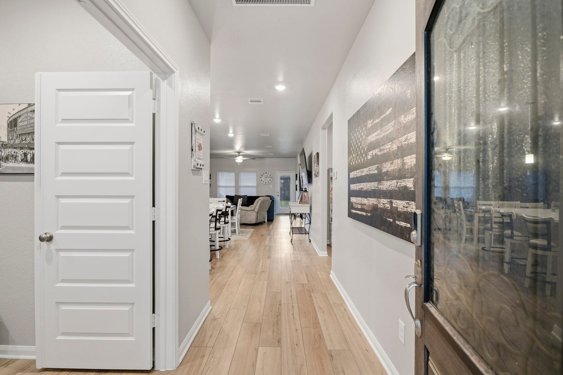 An inviting entryway with sleek floors leads to an open  kitchen and living space,