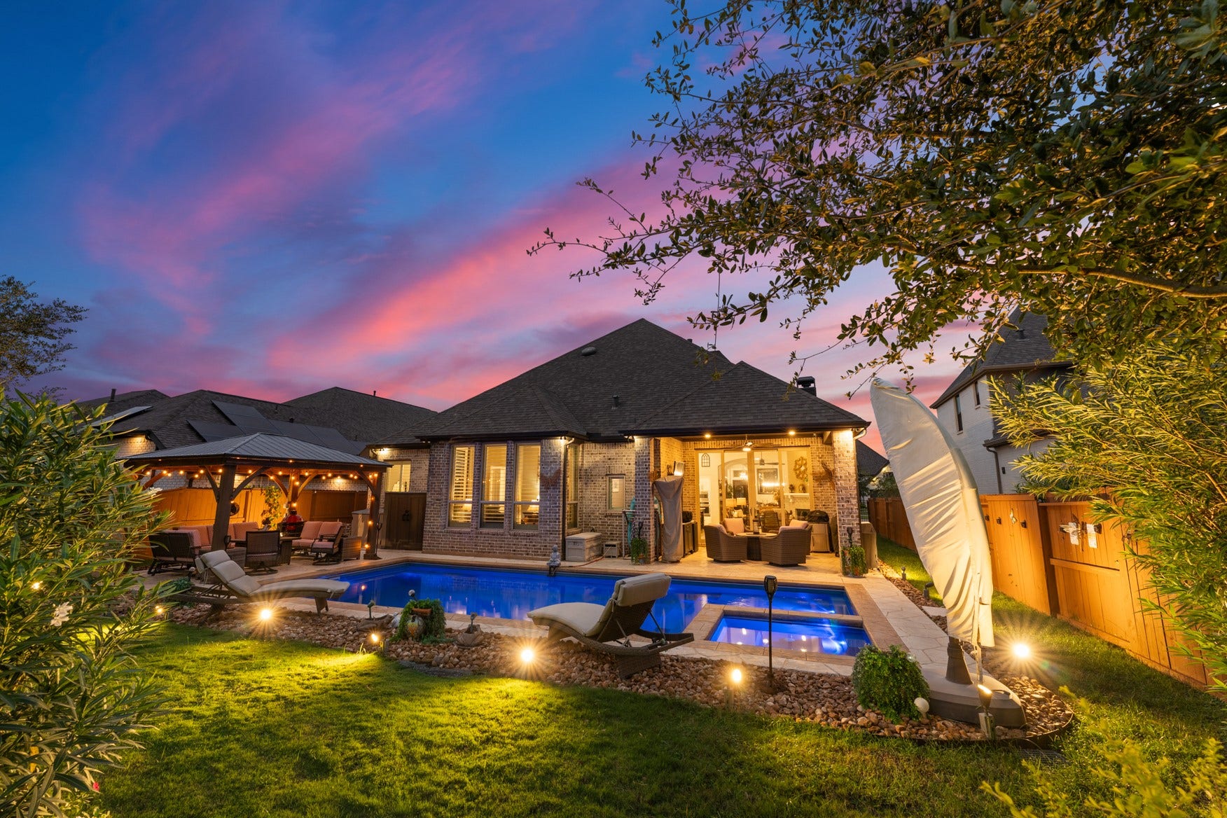 2214 Almond Creek Lane, Fulshear, TX 77423 Newly installed outdoor lighting transforms the backyard into an inviting nigttime retreat.