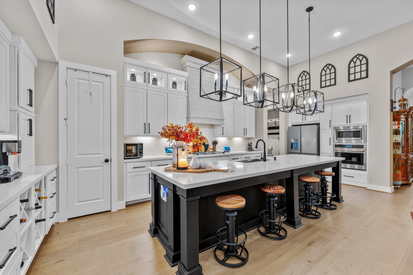 2214 Almond Creek Lane, Fulshear, TX 77423 An arched alcove over the cooking area and stylish vent hood gives the kitchen a custom look. The lighted topper cabinets with glass fronts let you showcase your favorite items!