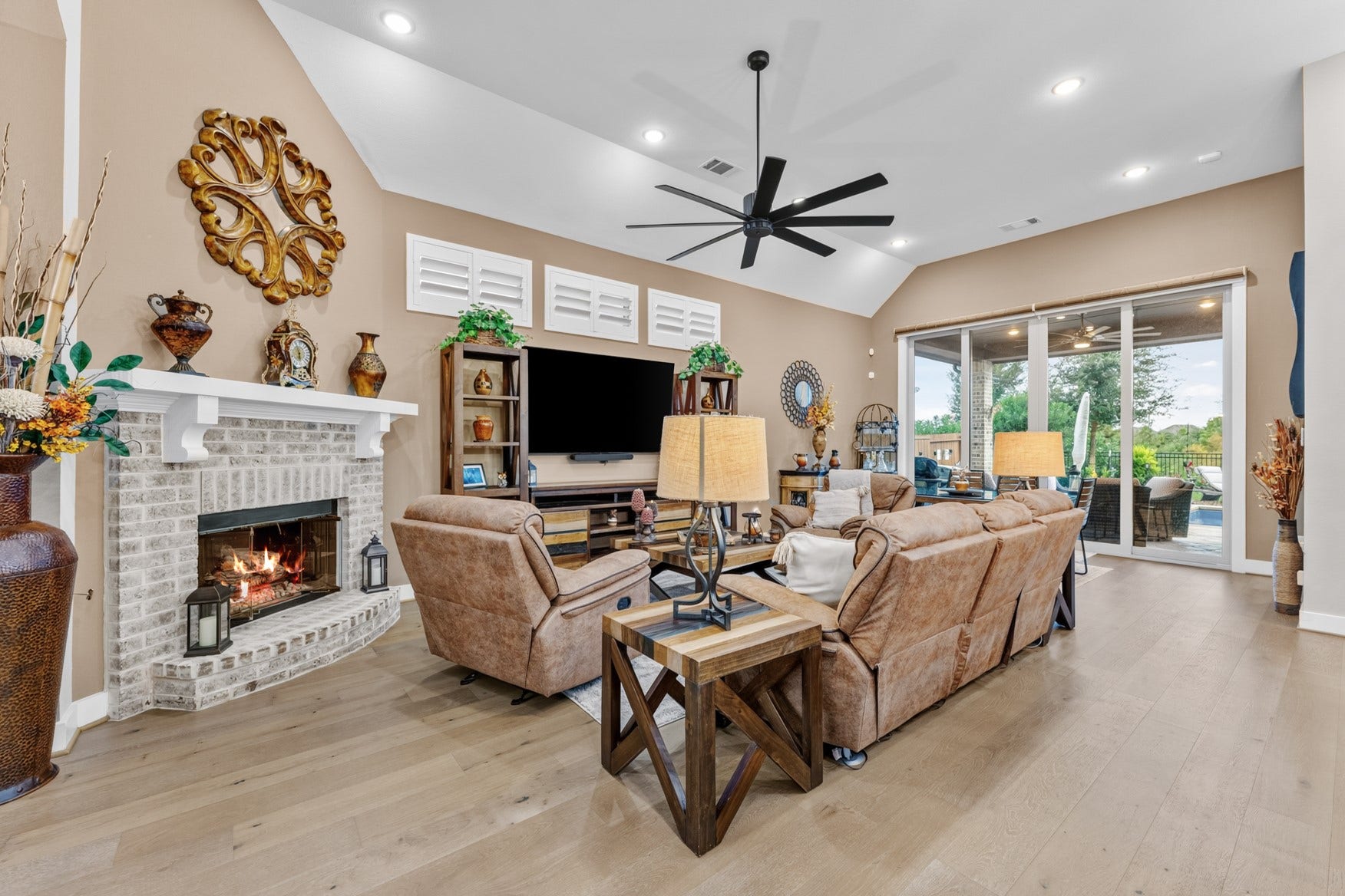 2214 Almond Creek Lane, Fulshear, TX 77423 Cozy up to the gas log fireplace on chilly nights. A four-paneled patio door makes indoor-outdoor living effortless.