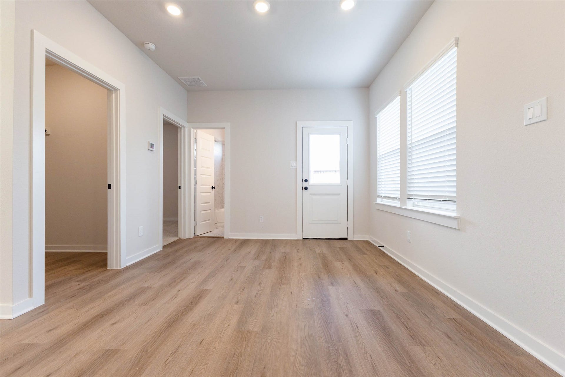 1007 Santee Ct Court, Rosharon, TX 77583 This hallway and utility area connects the main living space to the back door and secondary rooms, keeping everyday traffic away from the kitchen. A window lets in natural light, and the wood-look floors continue the same clean, low-maintenance finish used throughout. Doorways lead off to the bedroom wing and bath, giving the floor plan an easy flow and a bit of separation for quiet.