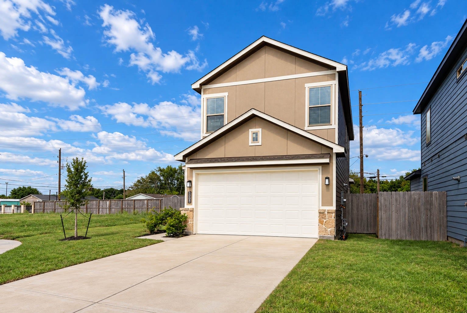 1007 Santee Ct Court, Rosharon, TX 77583 From this angle you can see how the stone-accented garage and the neutral exterior palette balance the home's two-story lines. The side fence adds privacy along the property edge, and the sidewalk and driveway make coming and going effortless. It is a clean, move-in-ready exterior with low-maintenance cement board and stucco, so weekends can be spent enjoying the neighborhood instead of upkeep.