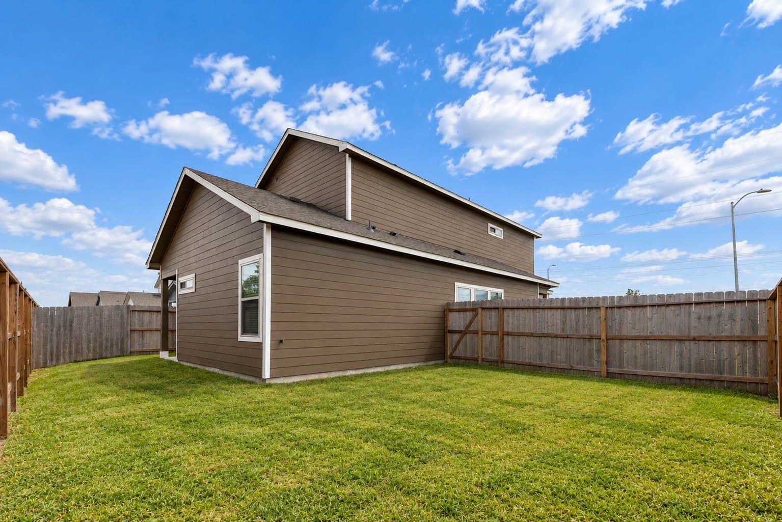 1007 Santee Ct Court, Rosharon, TX 77583 A final look at the backyard shows the full privacy fence, the neat lawn and the home's side and rear exterior with its durable siding and neutral color. With room to roam and an open sky above, it is a great setting for pets, play and entertaining. Combined with the community pool, splash pad, playground and trails nearby, outdoor living is easy here.