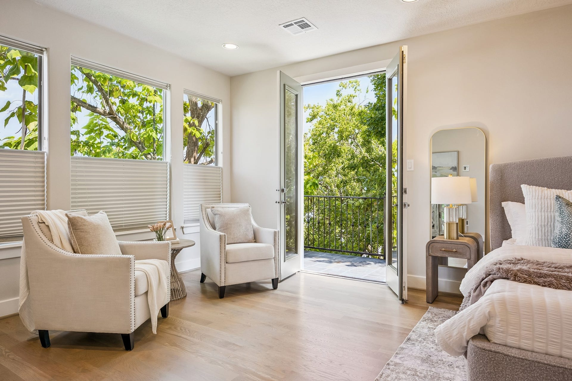 1477 Missouri Street, Houston, TX 77006 Primary suite with French doors opening to a private balcony surrounded by mature trees.