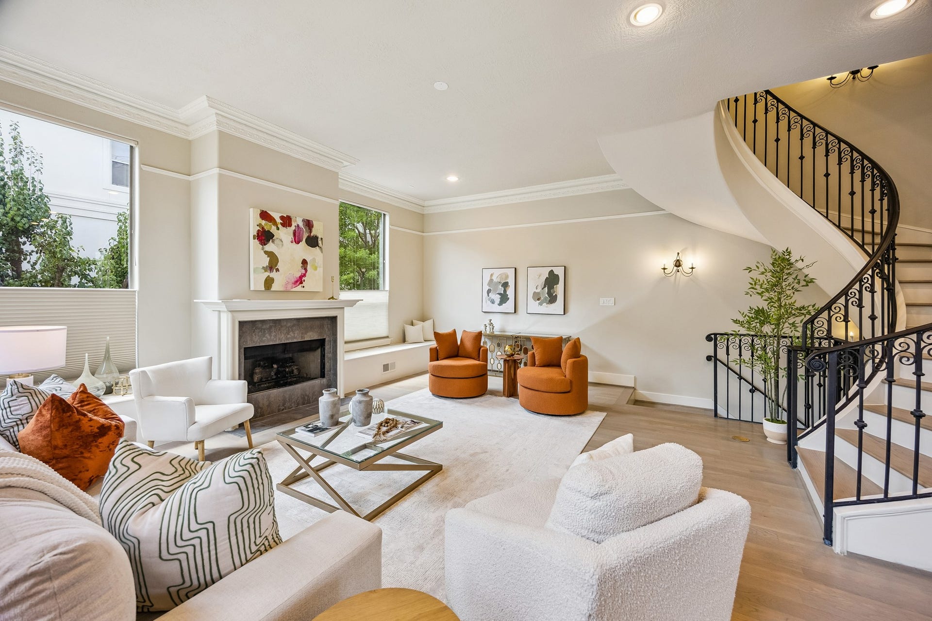 1477 Missouri Street, Houston, TX 77006 Generously proportioned living room with hardwood floors, high ceilings and windows on multiple sides, complemented by a dramatic curved staircase and an open, airy layout.