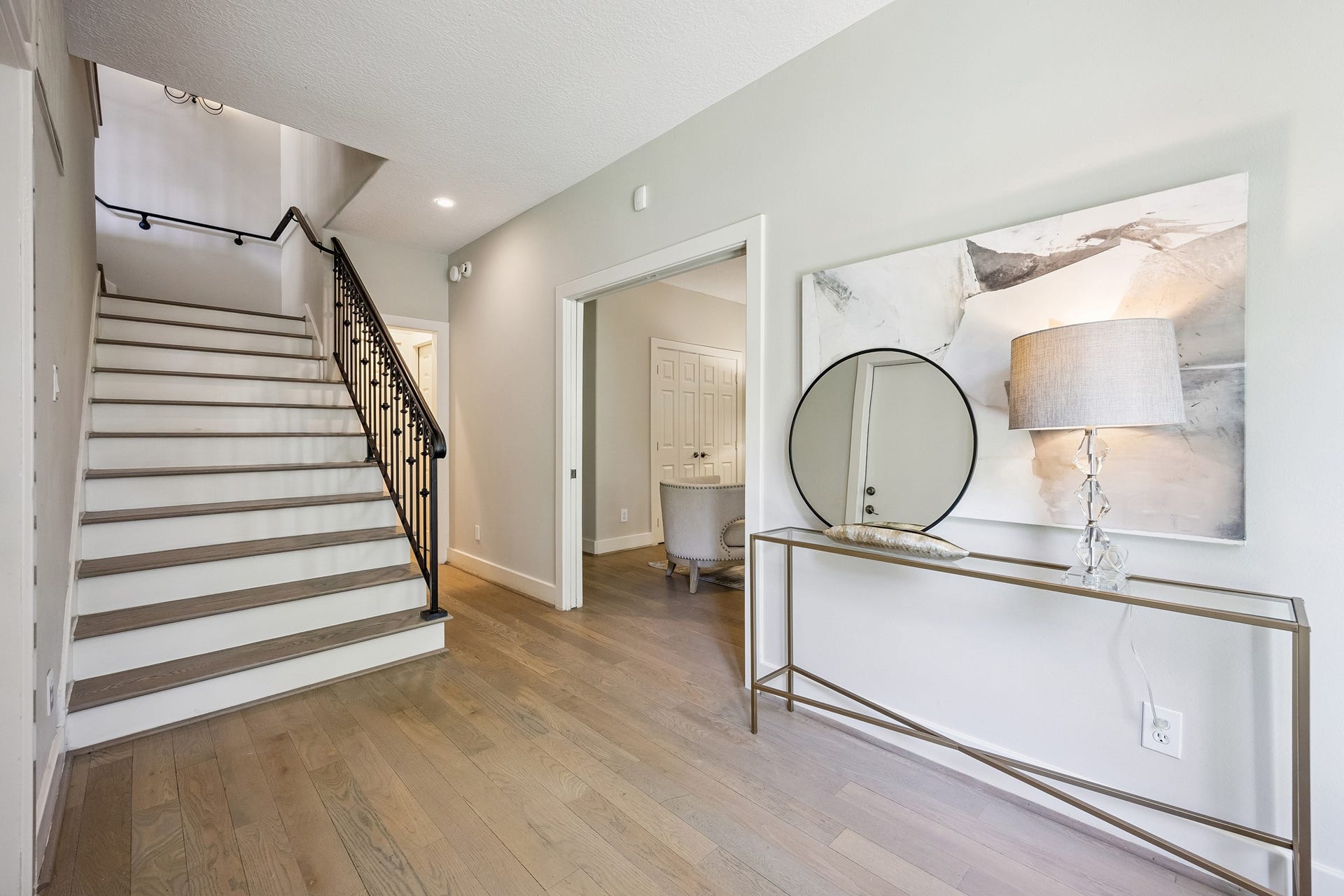 1477 Missouri Street, Houston, TX 77006 Light-filled entry hall with hardwood flooring and a curved staircase accented by an iron banister. Wood flooring continues throughout all living areas and bedrooms (no carpet).