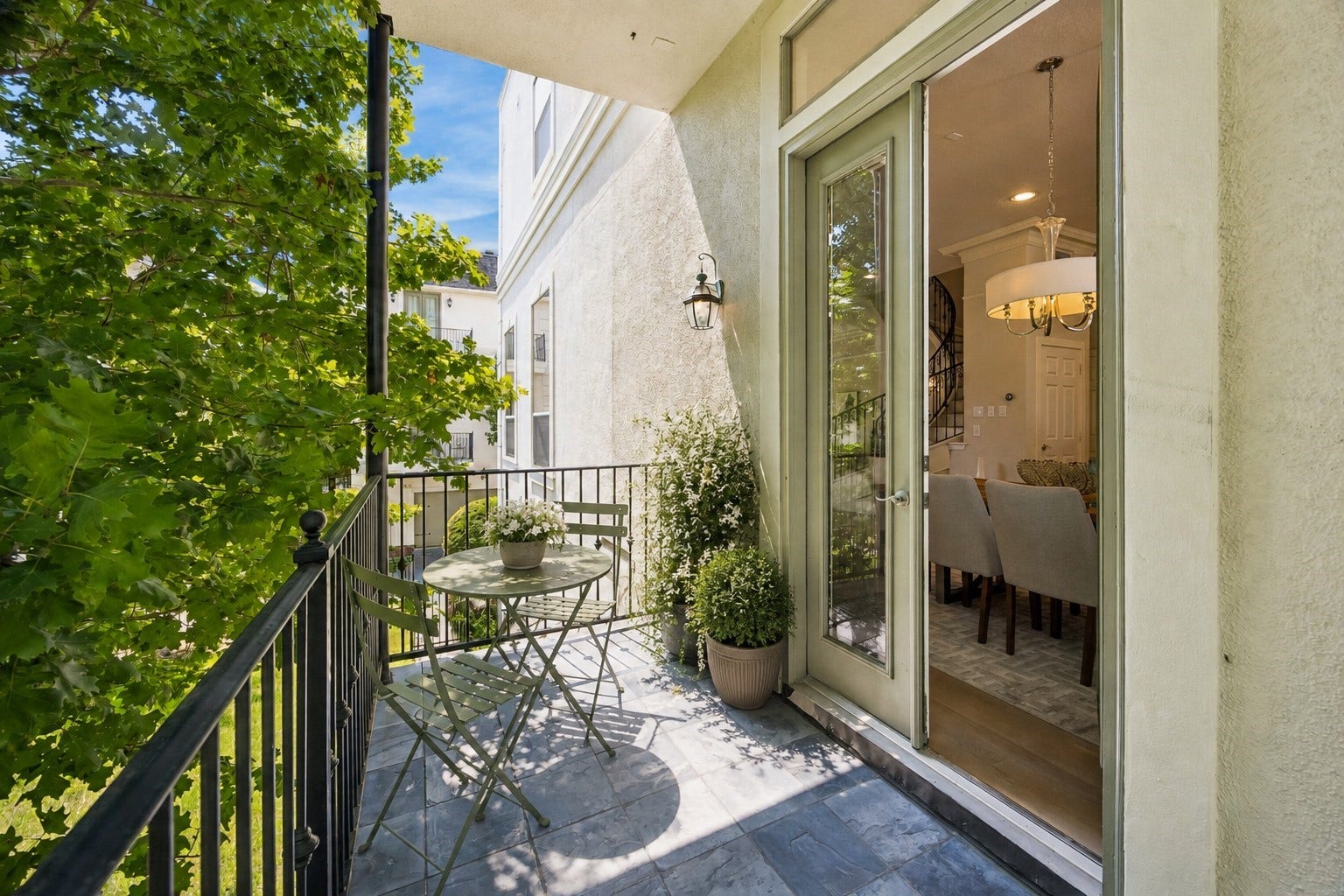 1477 Missouri Street, Houston, TX 77006 Dining-area balcony offering a shaded outdoor space surrounded by mature trees. Photo has been virtually staged.
