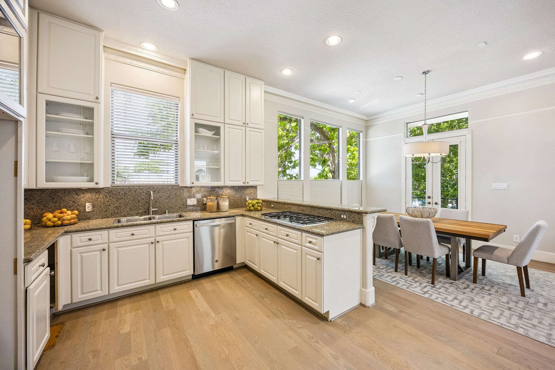 1477 Missouri Street, Houston, TX 77006 Kitchen with extensive cabinetry, under-cabinet lighting, granite counters, stainless-steel appliances and gas cooktop.