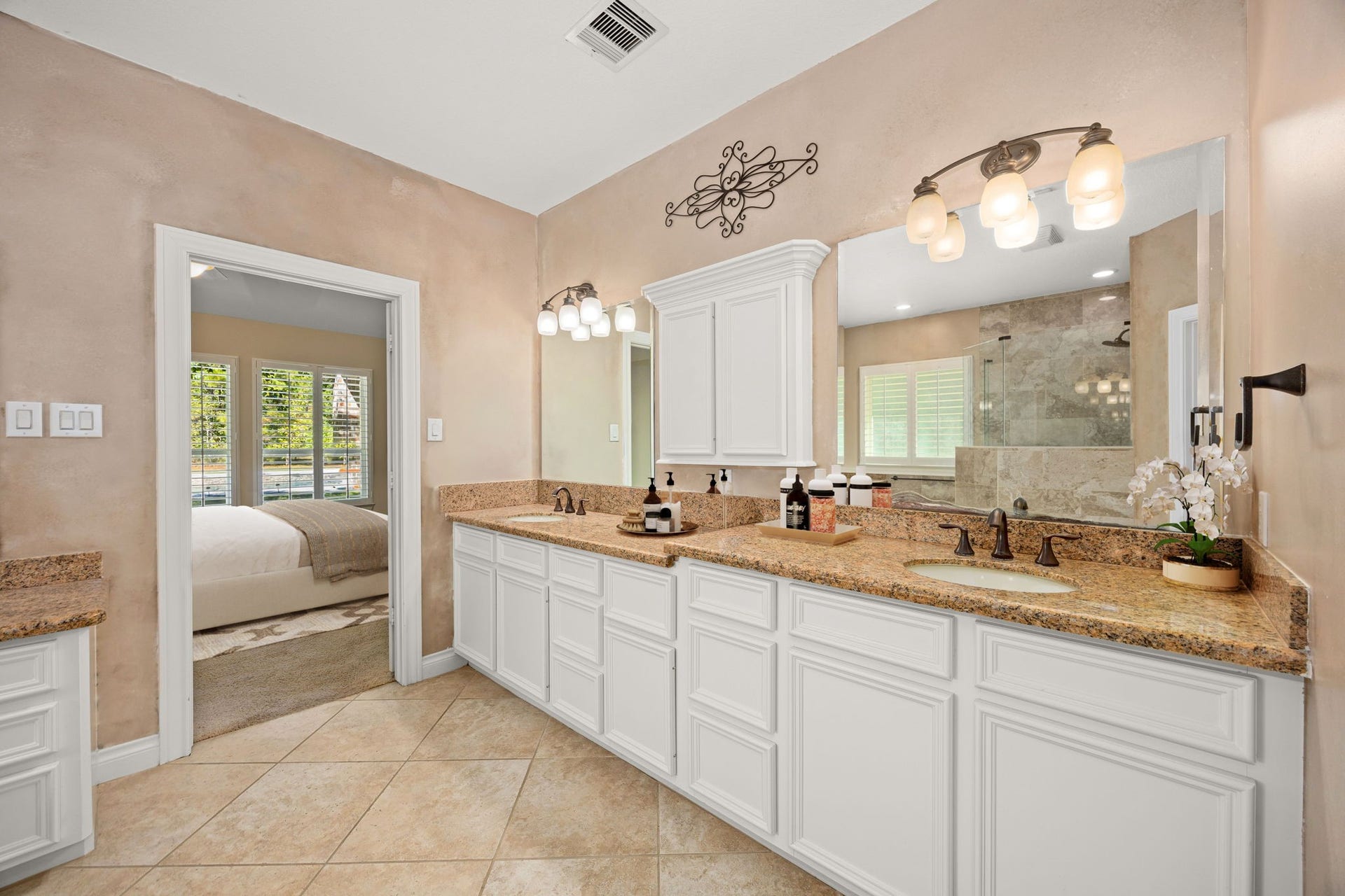 13506 Stagecoach Road, Magnolia, TX 77355 The primary bath offers a spa-like retreat with dual vanities, granite countertops, and elegant lighting. A spacious walk-in shower and neutral tile finishes create a serene, relaxing atmosphere, perfect for unwinding after a long day.