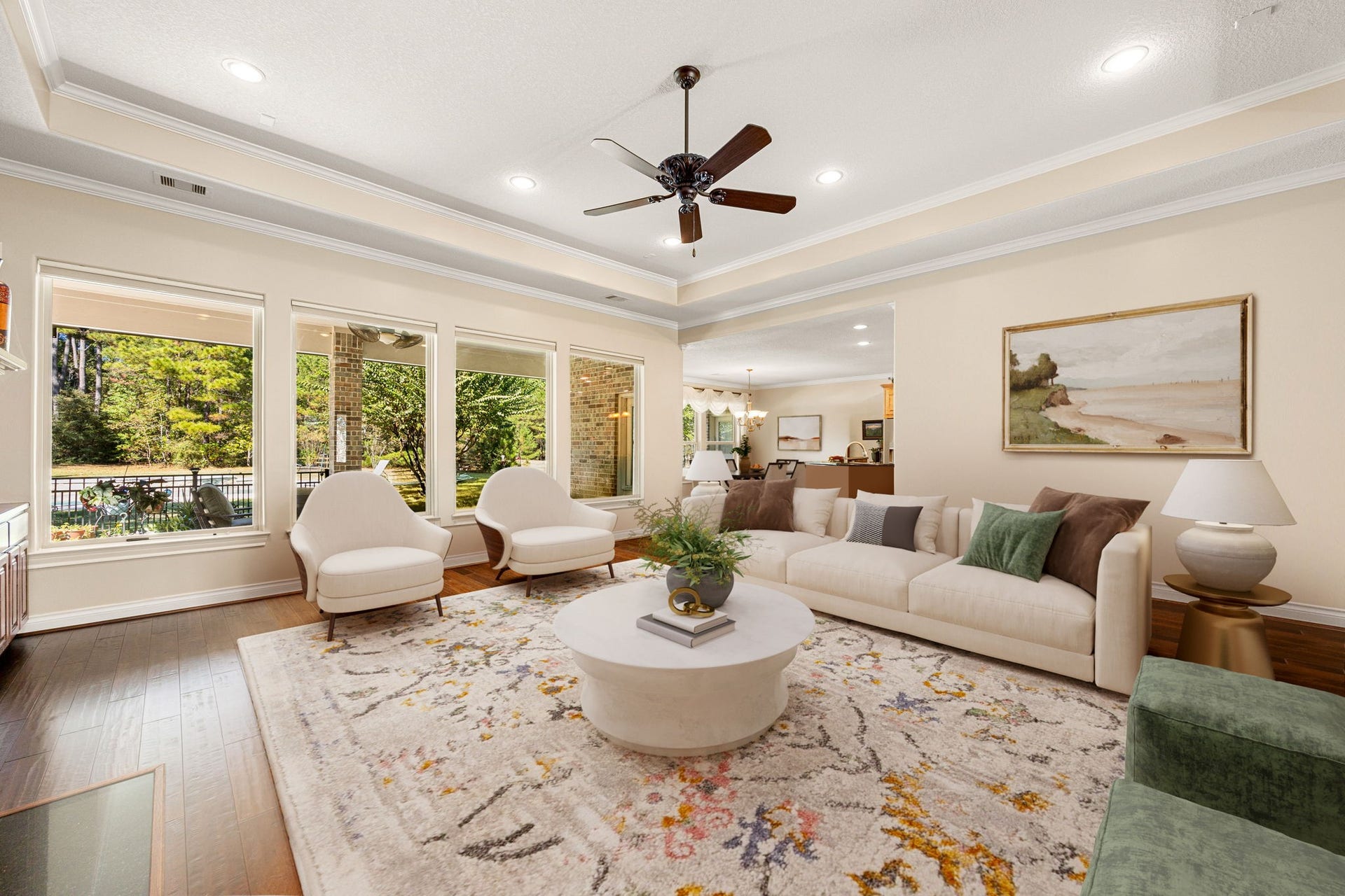13506 Stagecoach Road, Magnolia, TX 77355 This inviting living space features elegant tray ceilings, recessed lighting, and rich hardwood flooring. Expansive windows fill the room with natural light and offer serene views of the surrounding greenery. The open layout seamlessly connects to the kitchen and dining areas, creating an ideal setting for both relaxing and entertaining.