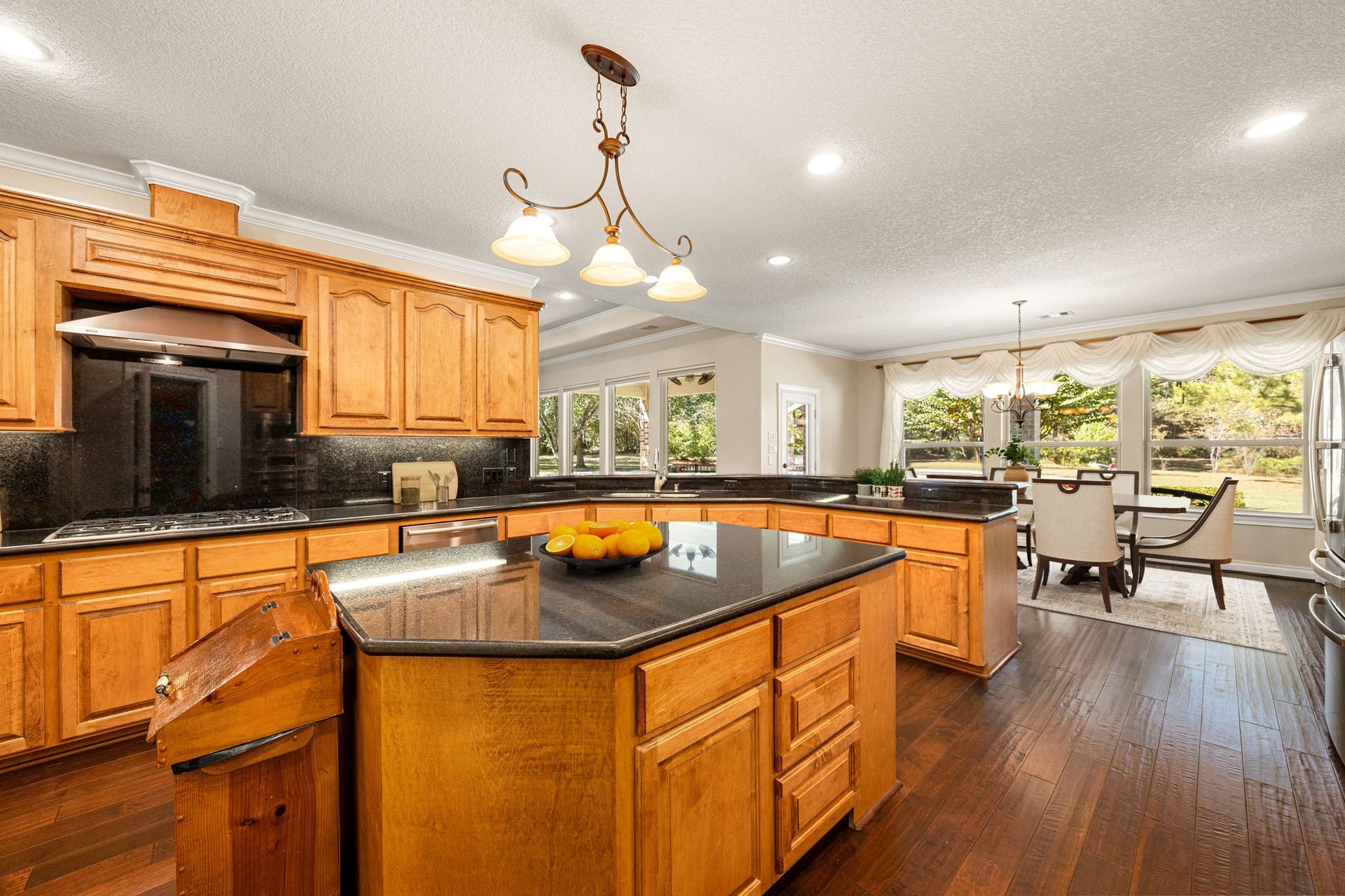 13506 Stagecoach Road, Magnolia, TX 77355 This impressive kitchen combines timeless charm and modern comfort, featuring rich custom cabinetry, sleek granite countertops, and a generous island ideal for gathering or meal prep. Expansive windows in the adjoining breakfast area bathe the space in natural light and offer beautiful backyard views for a bright, welcoming feel.