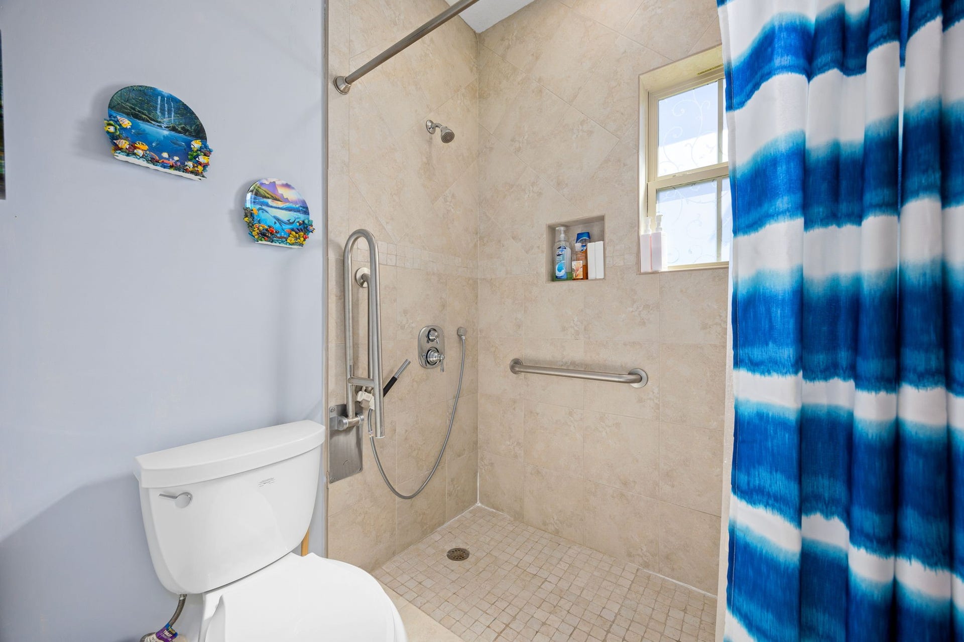13506 Stagecoach Road, Magnolia, TX 77355 This secondary bath features a beautifully tiled walk-in shower with accessibility upgrades, including grab bars and a handheld showerhead, combining style with thoughtful functionality.