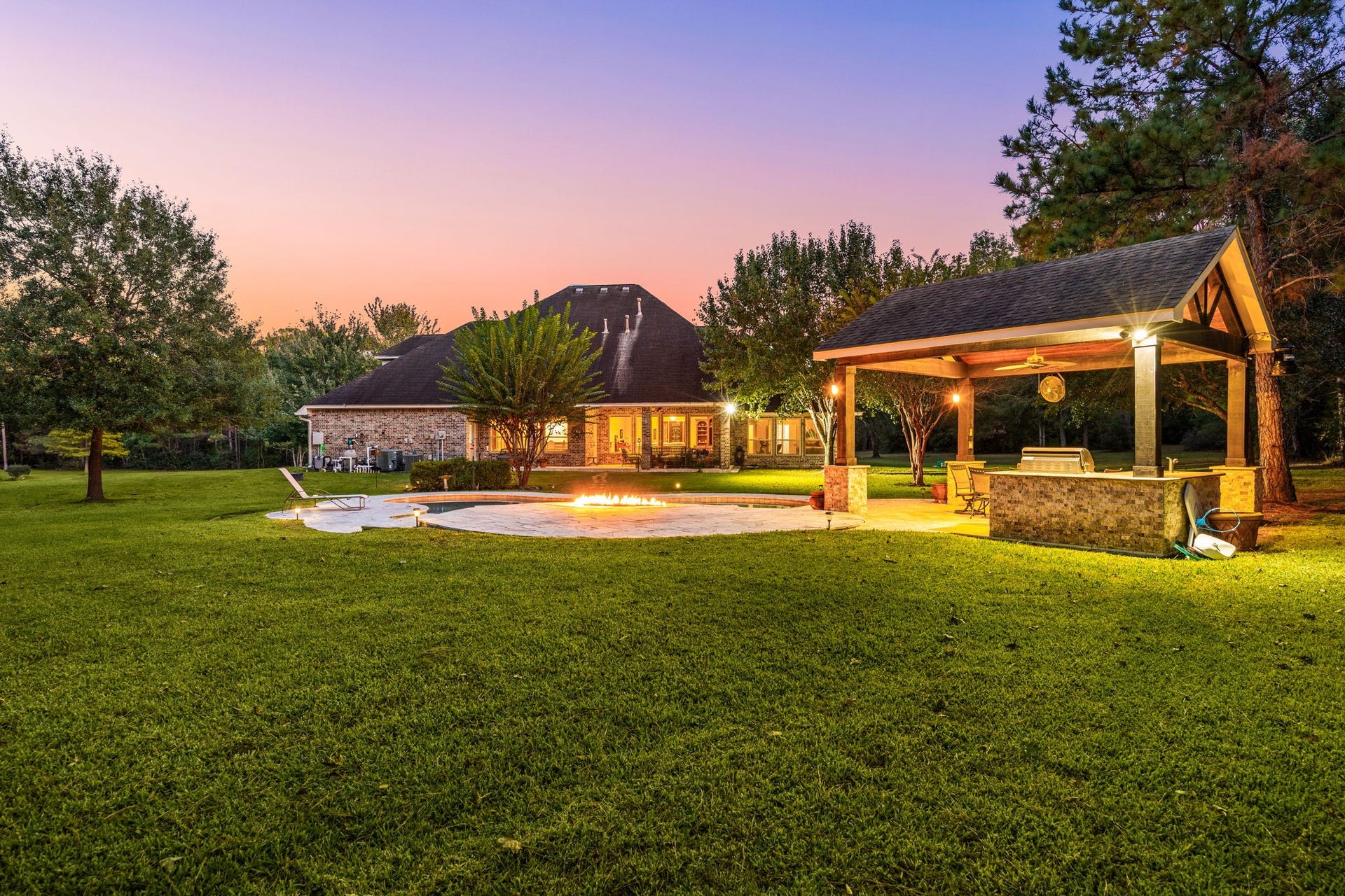 13506 Stagecoach Road, Magnolia, TX 77355 Step into a private outdoor escape where every detail invites relaxation and connection. A shimmering pool and glowing fire feature anchor the space, while the covered pavilion with a full outdoor kitchen makes entertaining effortless. Surrounded by mature trees and open lawn, this backyard offers an ideal balance of comfort and sophistication.