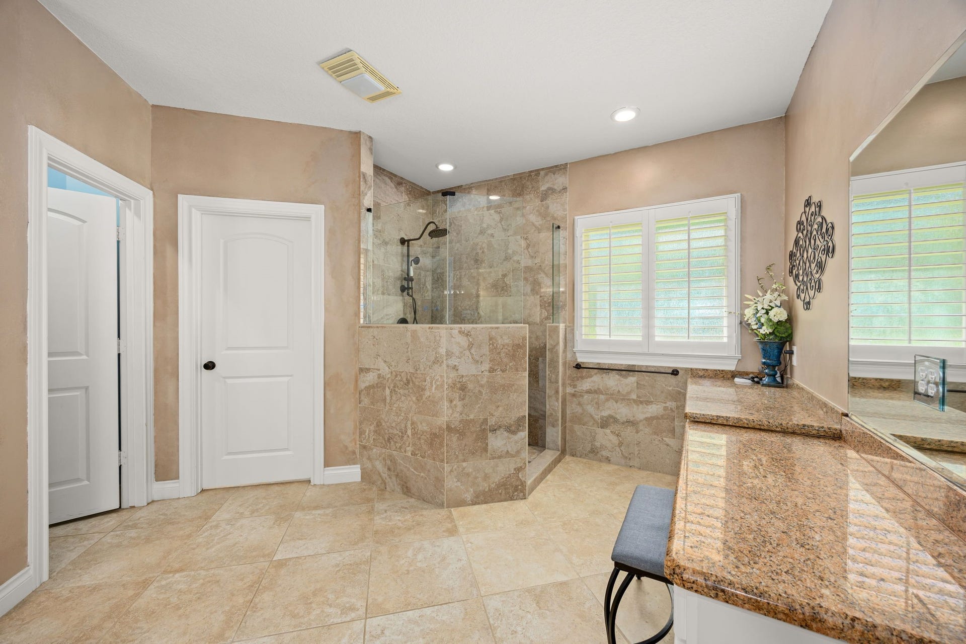 13506 Stagecoach Road, Magnolia, TX 77355 The luxurious primary bath showcases a large walk-in shower with elegant tile detail, granite countertops, and soft natural light. Designed for both function and relaxation, it provides a spa-inspired atmosphere right at home.