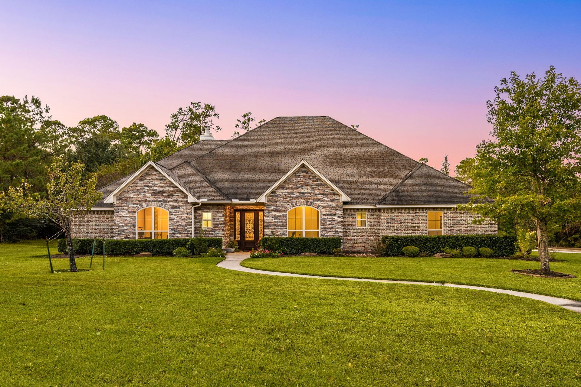 13506 Stagecoach Road, Magnolia, TX 77355 Nestled on a beautifully landscaped, tree-lined property, this home showcases a classic brick and stone elevation, a welcoming front porch entry, and a lush rolling lawn that enhances its exceptional curb appeal. Experience the perfect blend of privacy, comfort, and sophistication, all within minutes of modern conveniences and top-rated Tomball ISD schools.