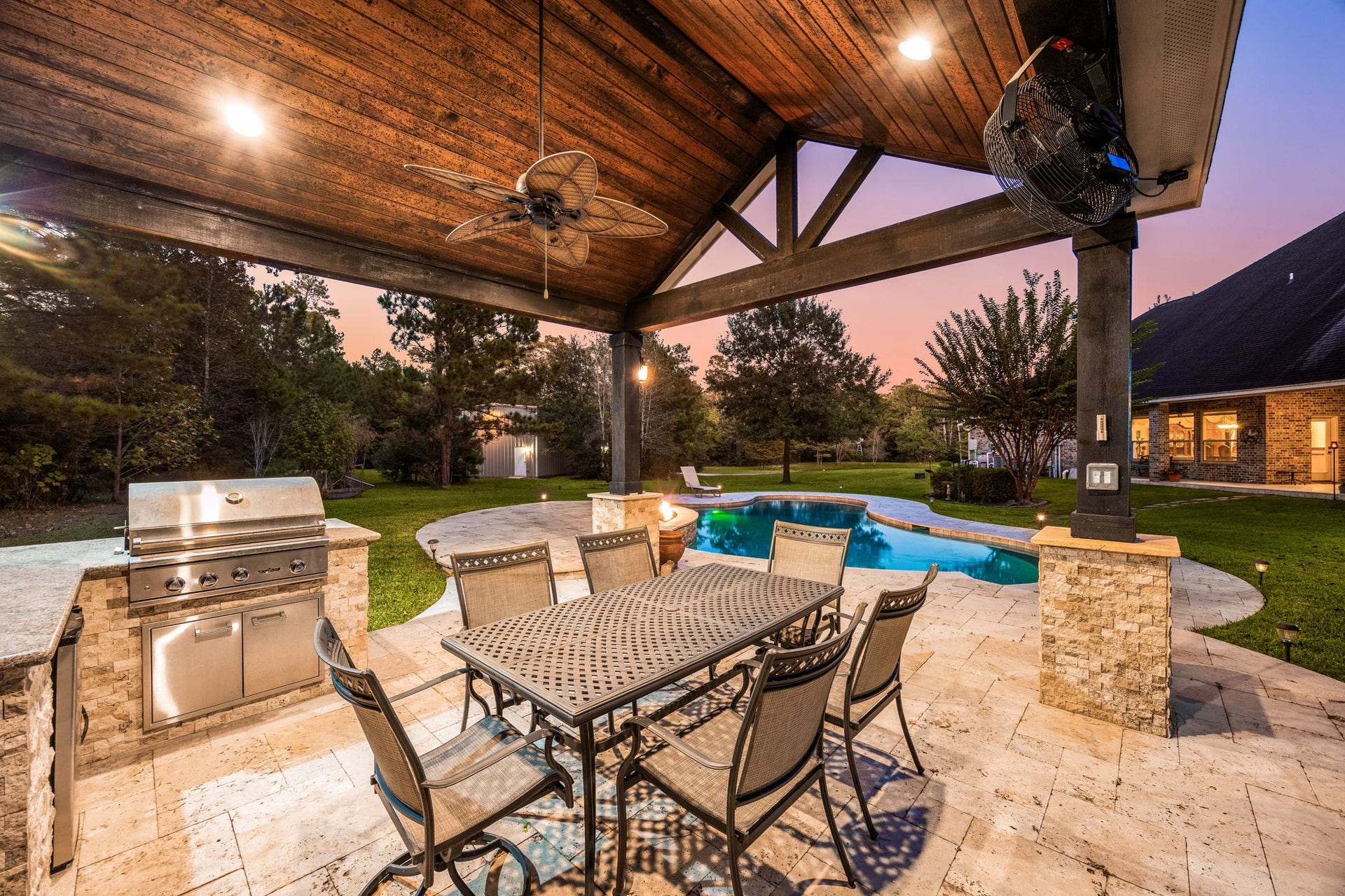 13506 Stagecoach Road, Magnolia, TX 77355 Experience true outdoor luxury beneath the custom pavilion featuring wood-beamed ceilings, built-in grill, and tranquil views of the sparkling pool and wooded backdrop, perfect for elegant entertaining or peaceful evenings under the Texas sky.