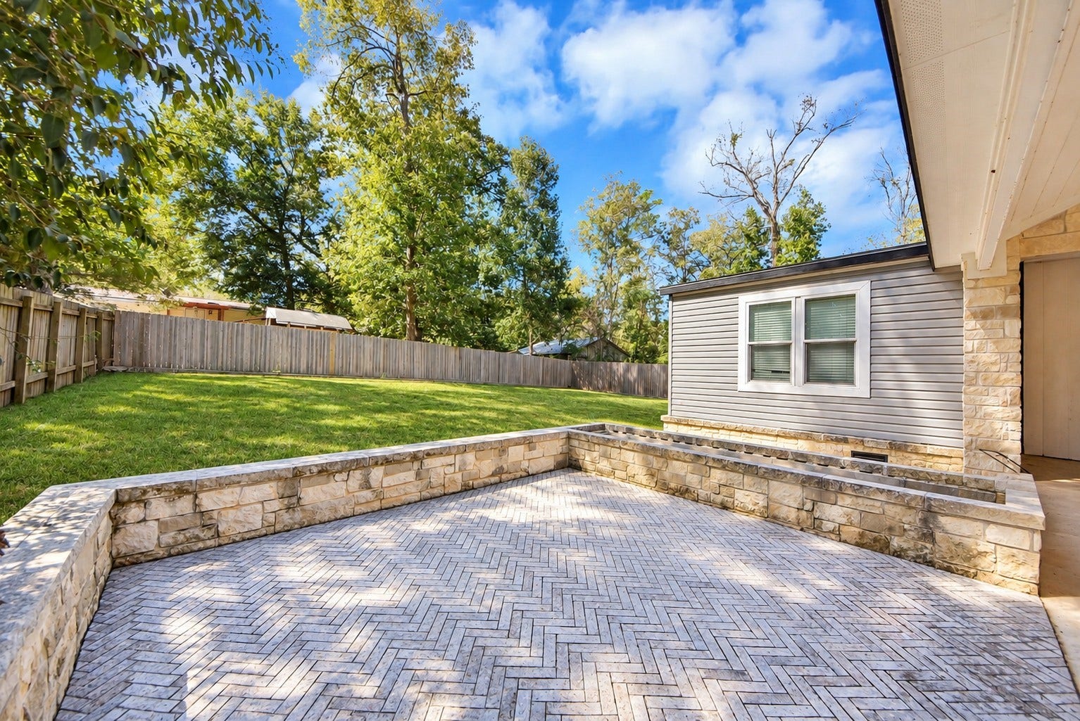 12565 Royal Green Drive, Conroe, TX 77303 Spacious open-air patio with stone pavers, directly connecting to the expansive backyard.