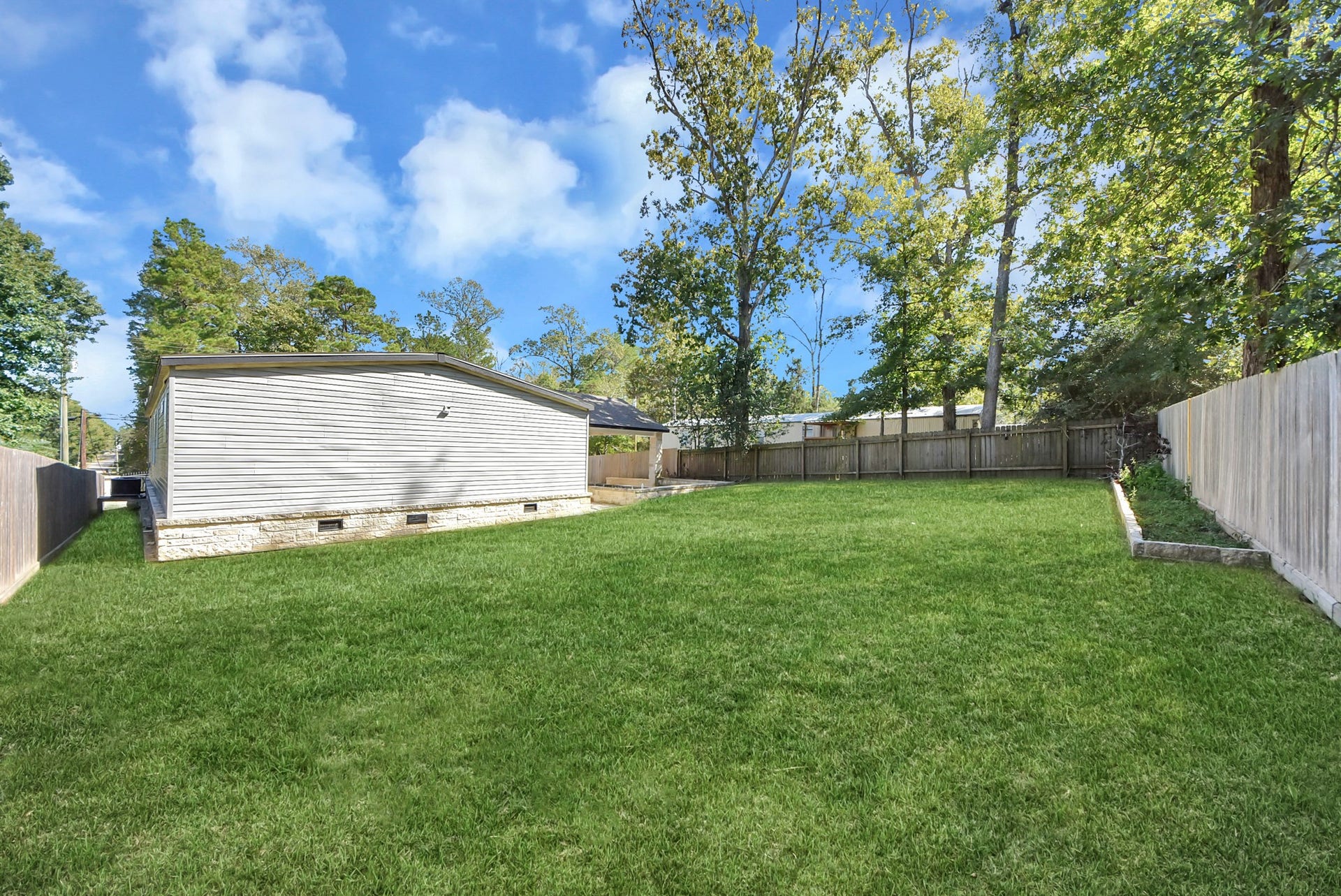 12565 Royal Green Drive, Conroe, TX 77303 Spacious backyard with lush greenery.