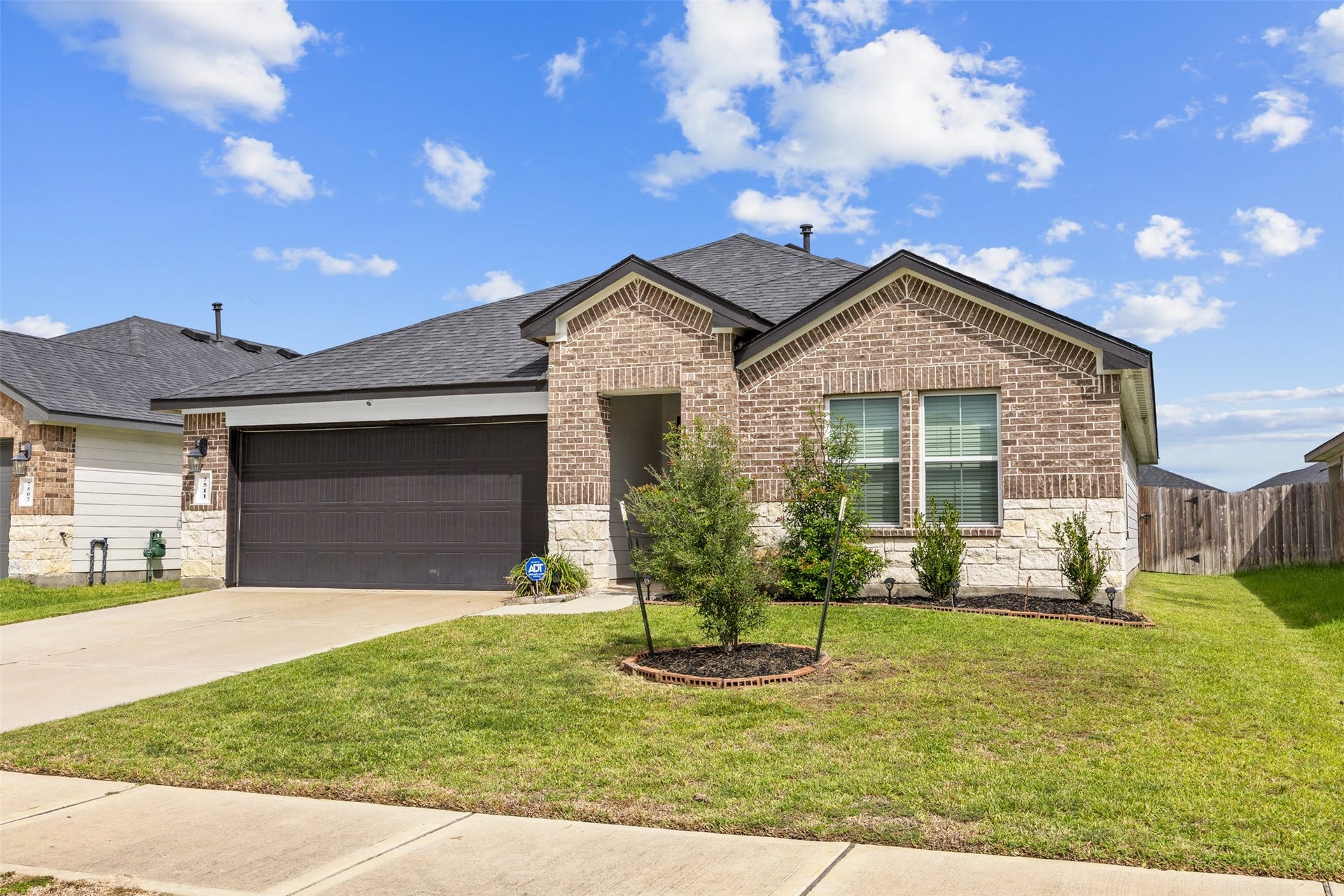 7511 Carson Court, Rosharon, TX 77583 A charming brick-and-stone exterior welcomes you home, complete with a spacious driveway and attached two-car garage.