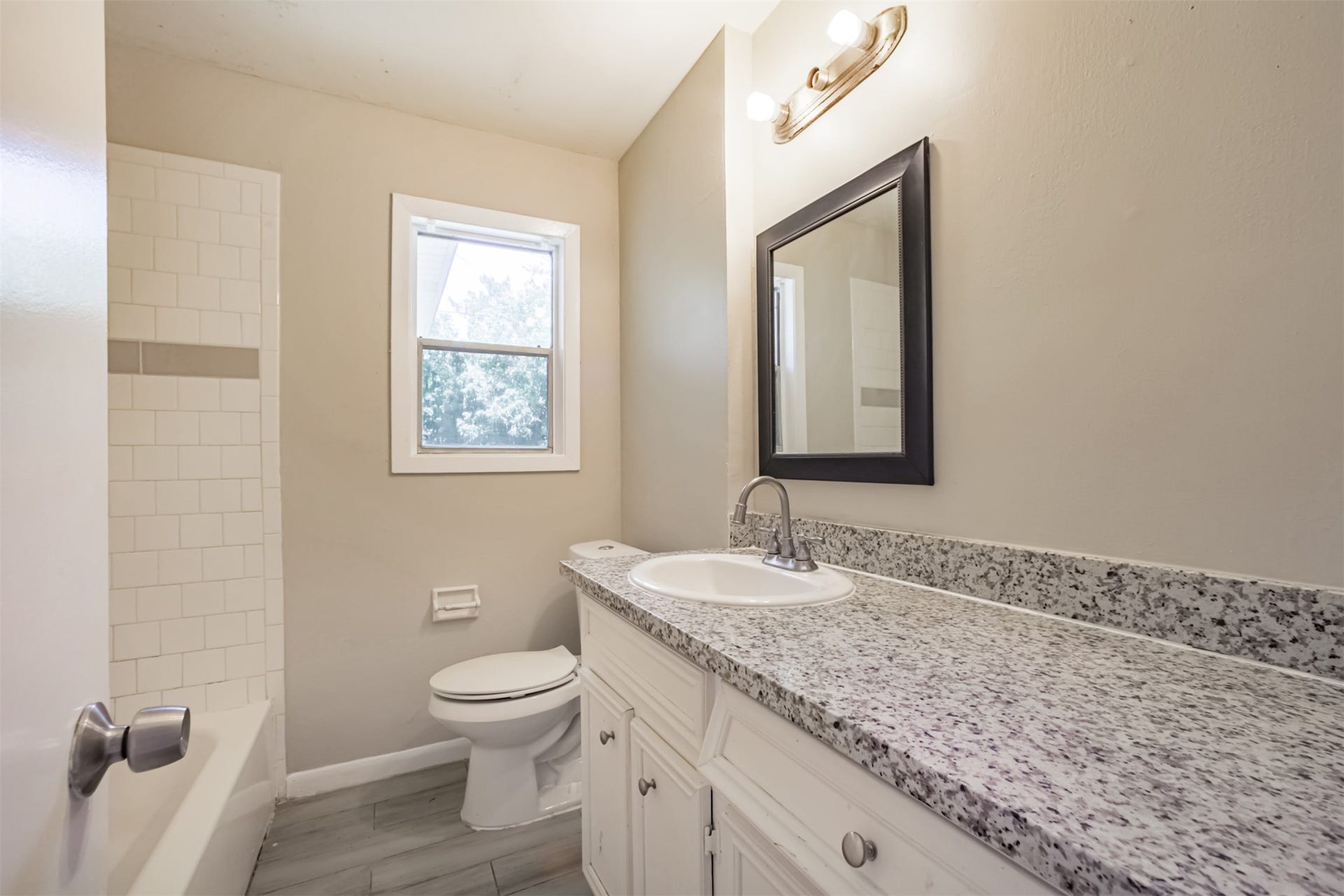 Hall bath has long vanity with granite counter