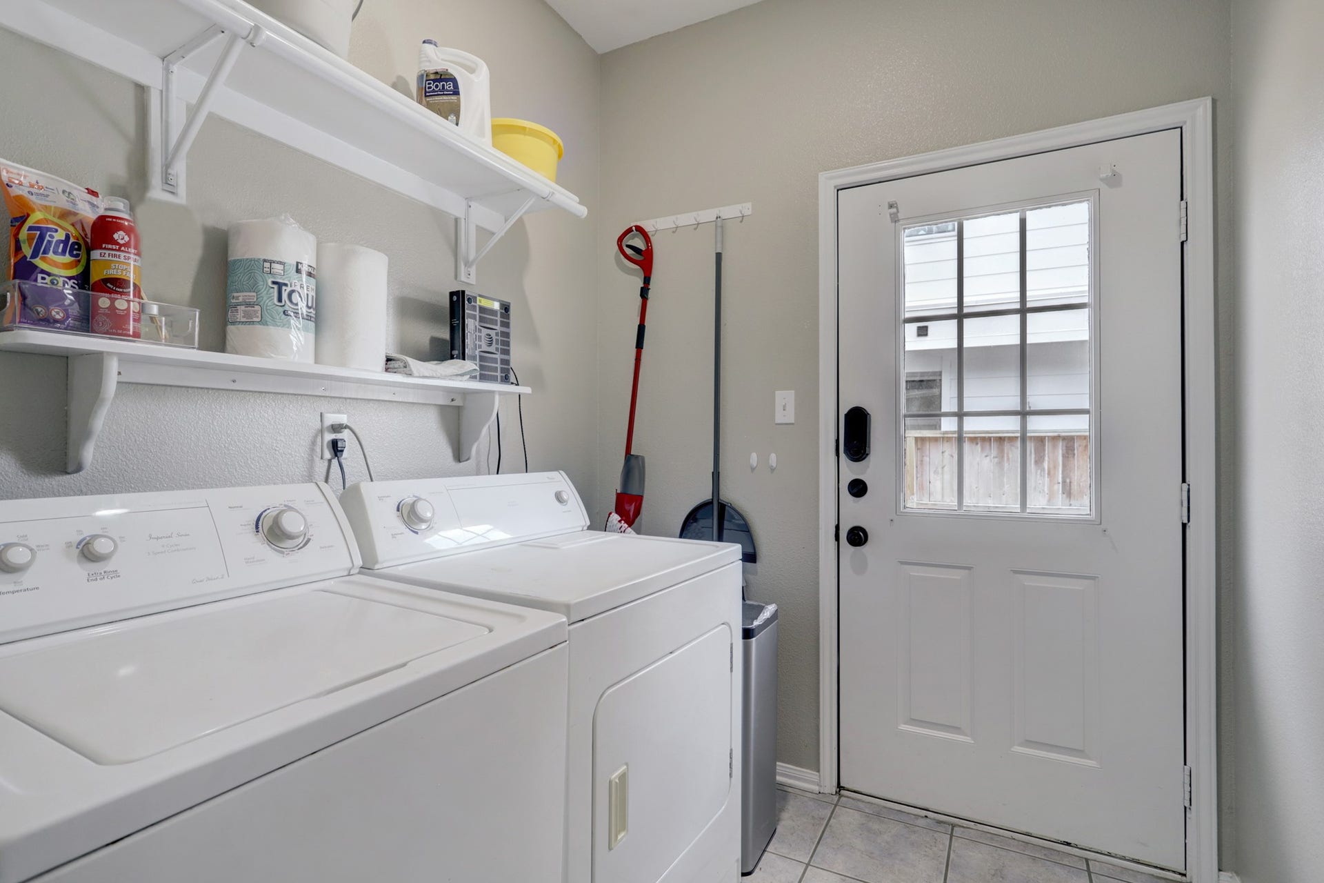 803 Dorothy Street, Houston, TX 77007 Dedicated laundry area with washer, dryer, storage shelving, and convenient exterior access.