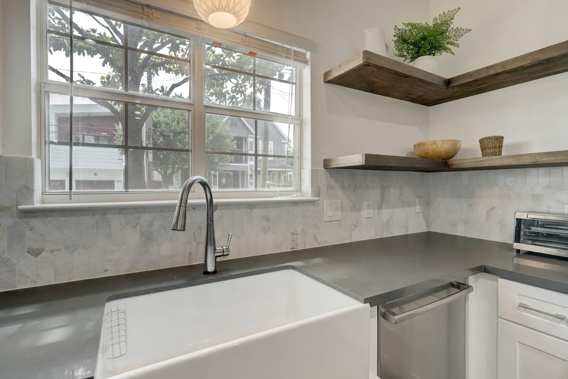 803 Dorothy Street, Houston, TX 77007 Kitchen sink overlooking the outdoors, complemented by open shelving, modern fixtures, and a stylish backsplash.