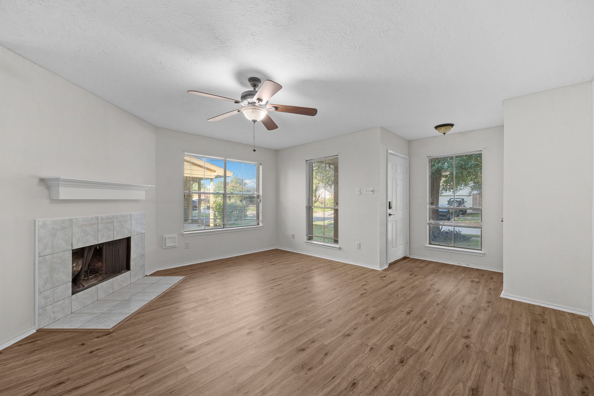 15506 Appleridge Drive, Houston, TX 77489 Bright and inviting living room featuring a cozy fireplace, elegant flooring, and large windows that offer plenty of natural light.