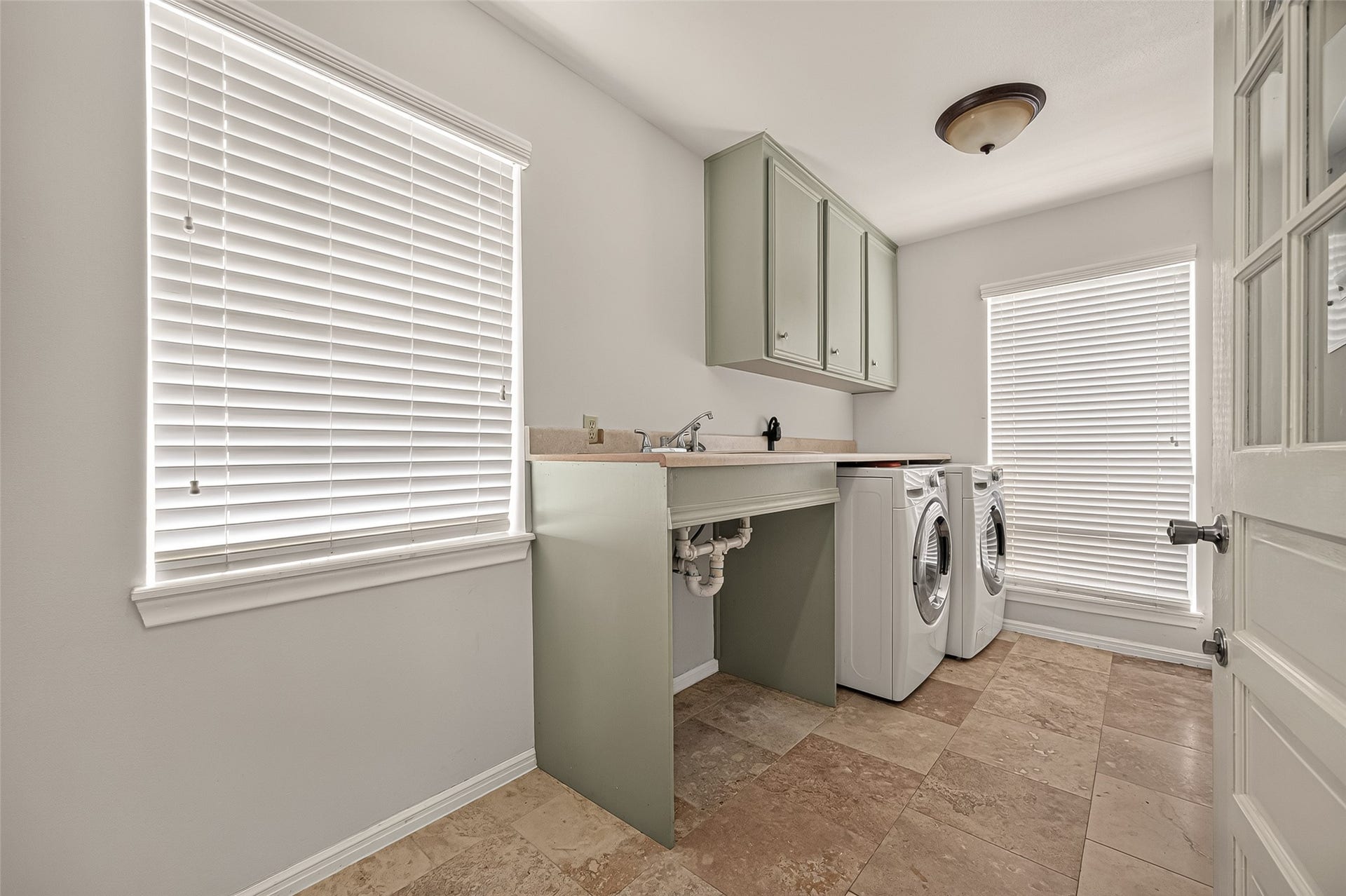 8007 Vickridge Lane, Spring, TX 77379 Conveniently located just off the kitchen, the spacious laundry room offers abundant natural light, built-in storage, and a convenient door leading to the covered walkway connecting the garage and backyard
