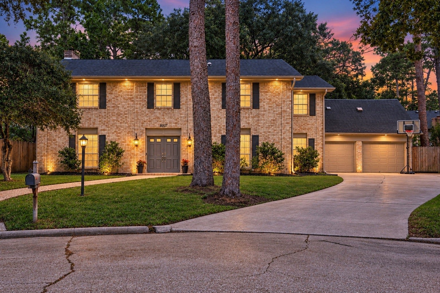 8007 Vickridge Lane, Spring, TX 77379 Beautifully illuminated at twilight, this classic brick home welcomes you with a warm glow, mature trees, and inviting curb appeal