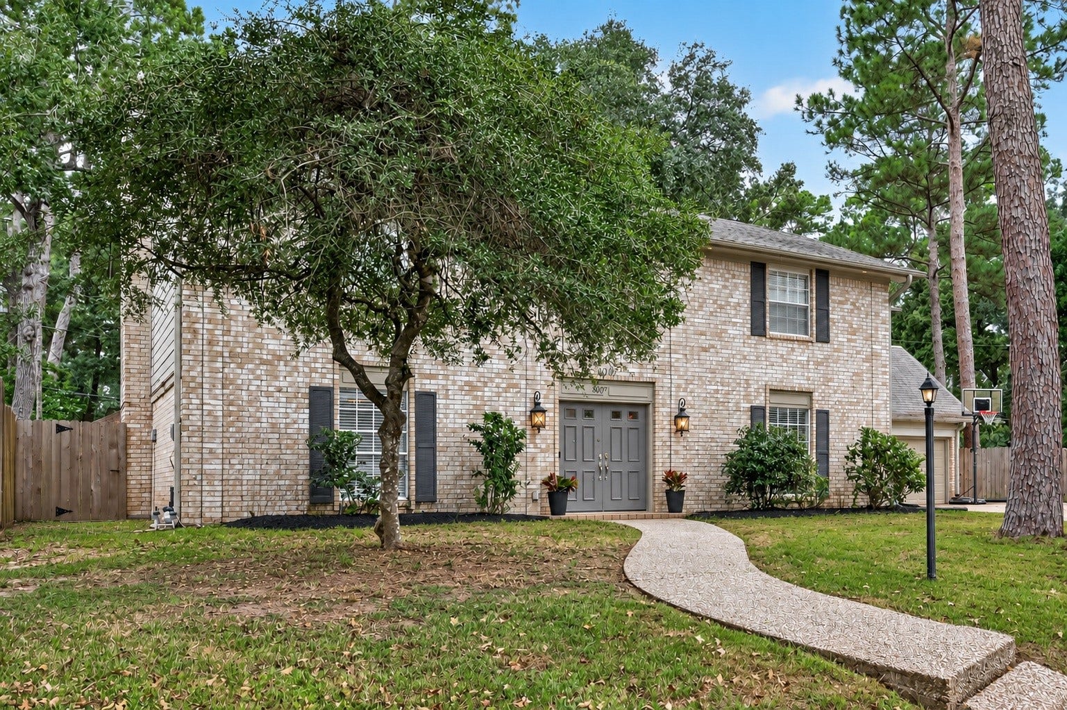 8007 Vickridge Lane, Spring, TX 77379 A beautiful, tree-shaded yard with established garden beds waiting for your personal touch.
