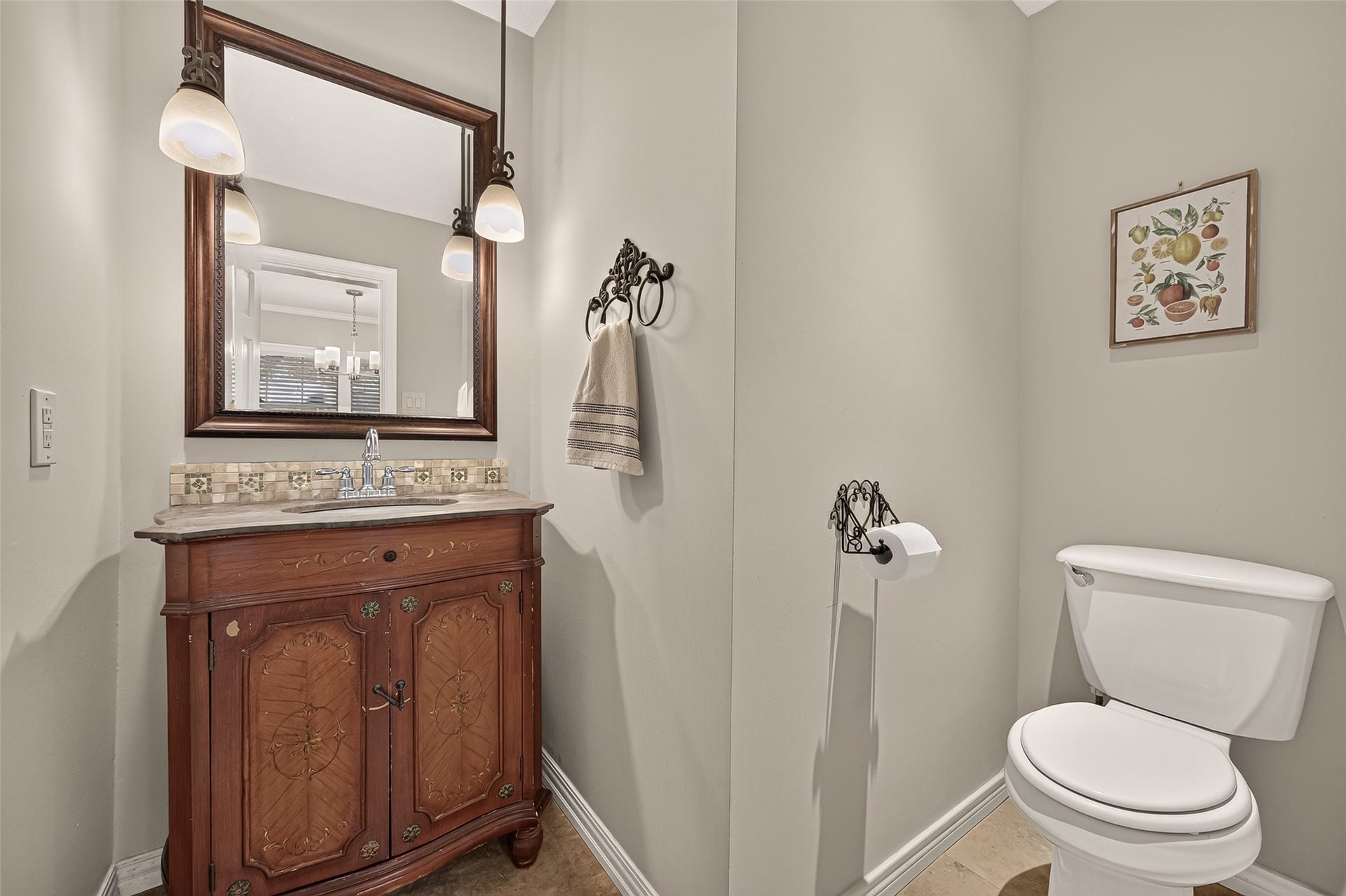 8007 Vickridge Lane, Spring, TX 77379 Charming half bath features a beautifully detailed vintage-style vanity, elegant lighting, and timeless character
