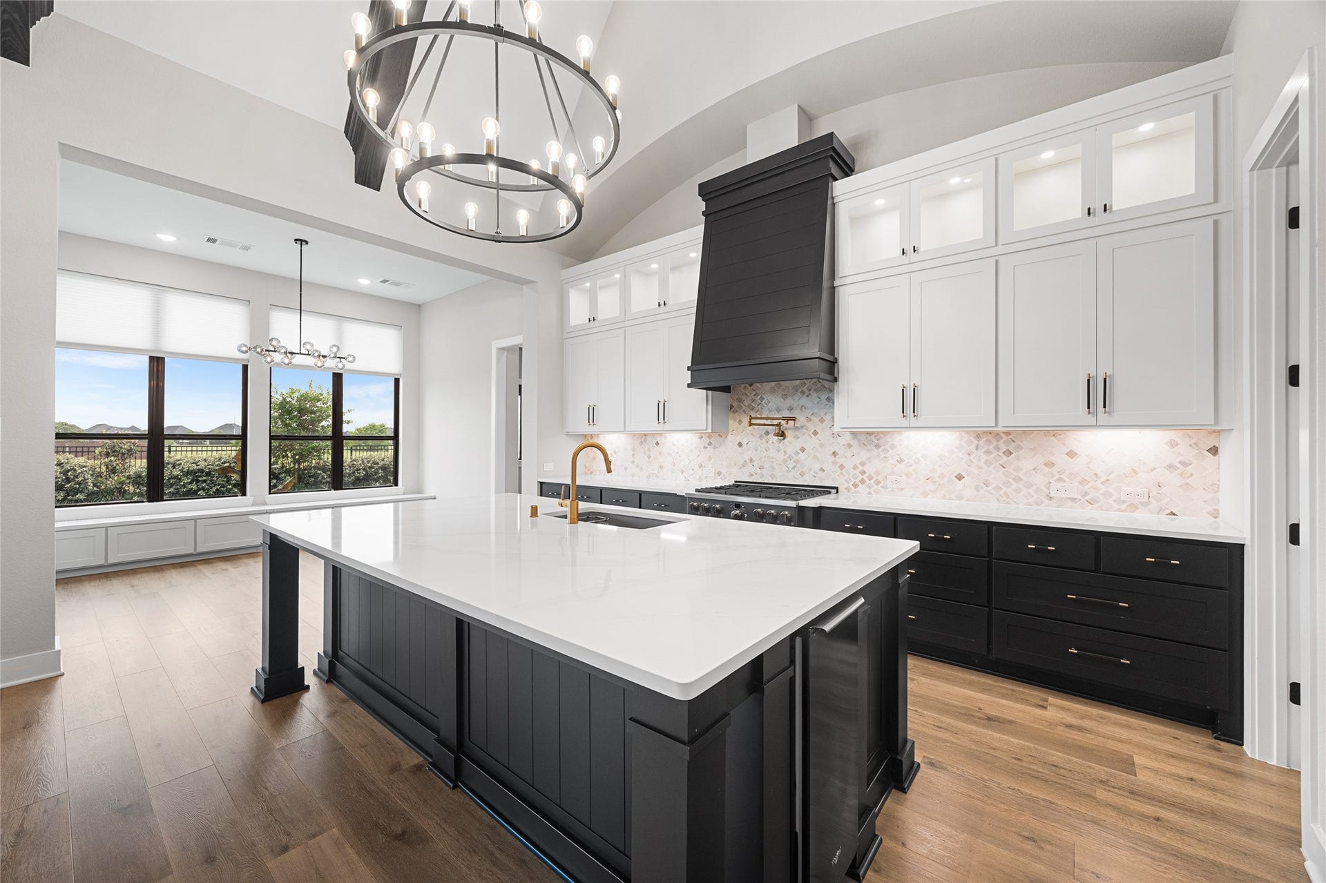 6707 Nimitz Court, Katy, TX 77493 Expansive island with integrated sink and seating potential, complemented by custom cabinetry, designer backsplash, and abundant natural light from adjacent windows.