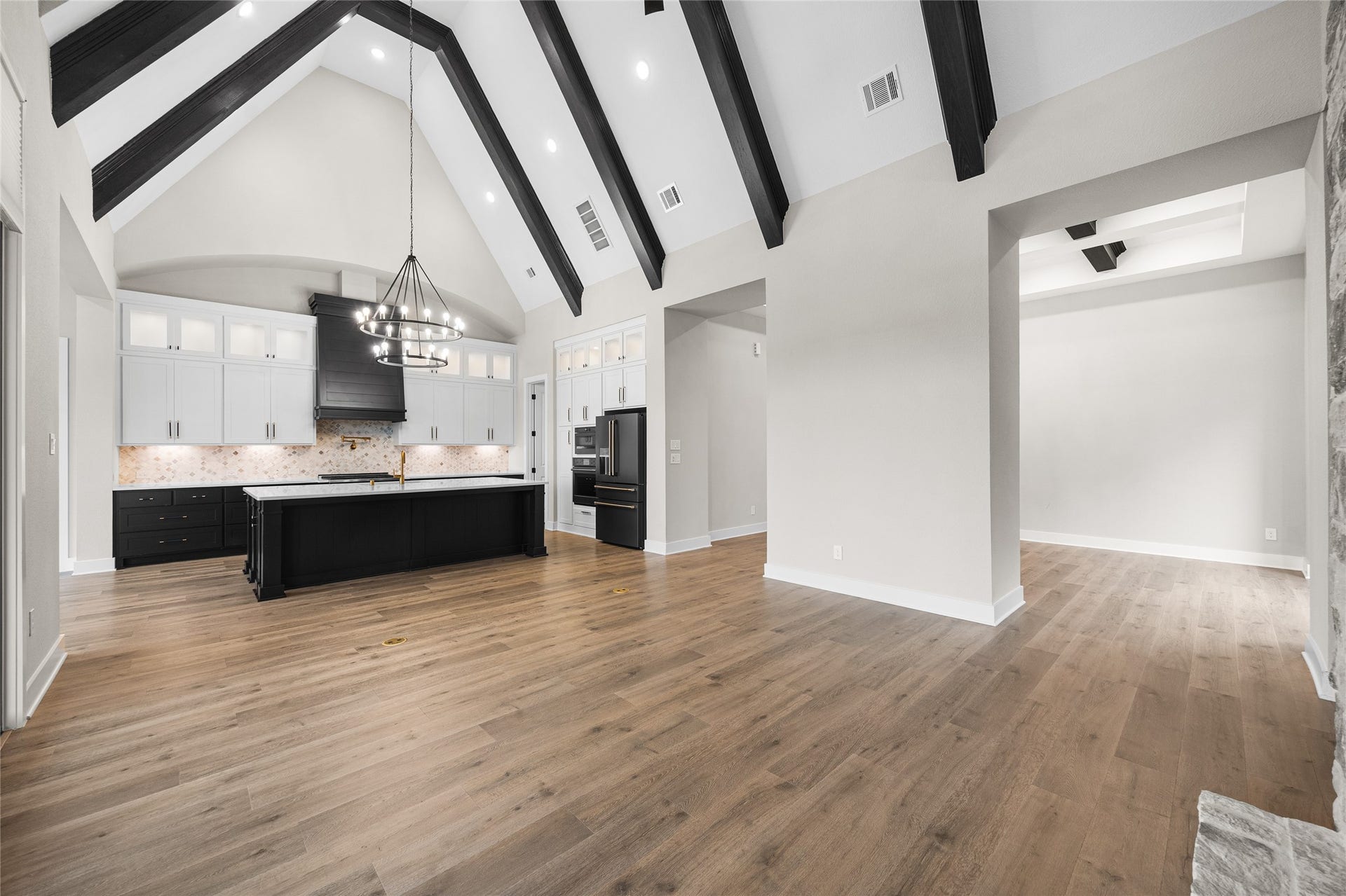 6707 Nimitz Court, Katy, TX 77493 Seamless flow between kitchen and living space, featuring vaulted ceilings with exposed beams and large windows that bring in abundant natural light.