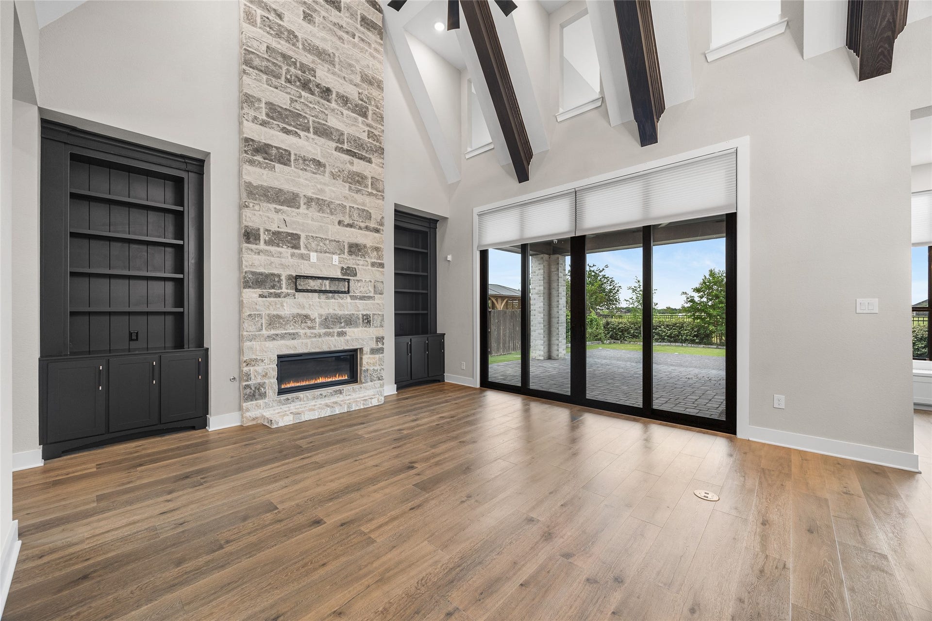 6707 Nimitz Court, Katy, TX 77493 Bright and airy living space showcasing custom built-ins flanking the fireplace and wide-plank flooring throughout, ideal for both relaxation and entertaining.