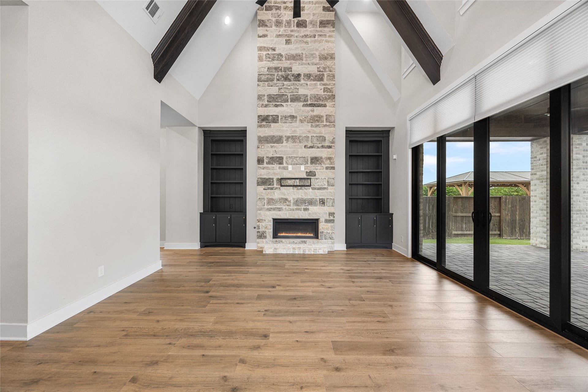 6707 Nimitz Court, Katy, TX 77493 Stunning focal fireplace with modern linear design set in a full-height stone surround, framed by built-in shelving and cabinetry.