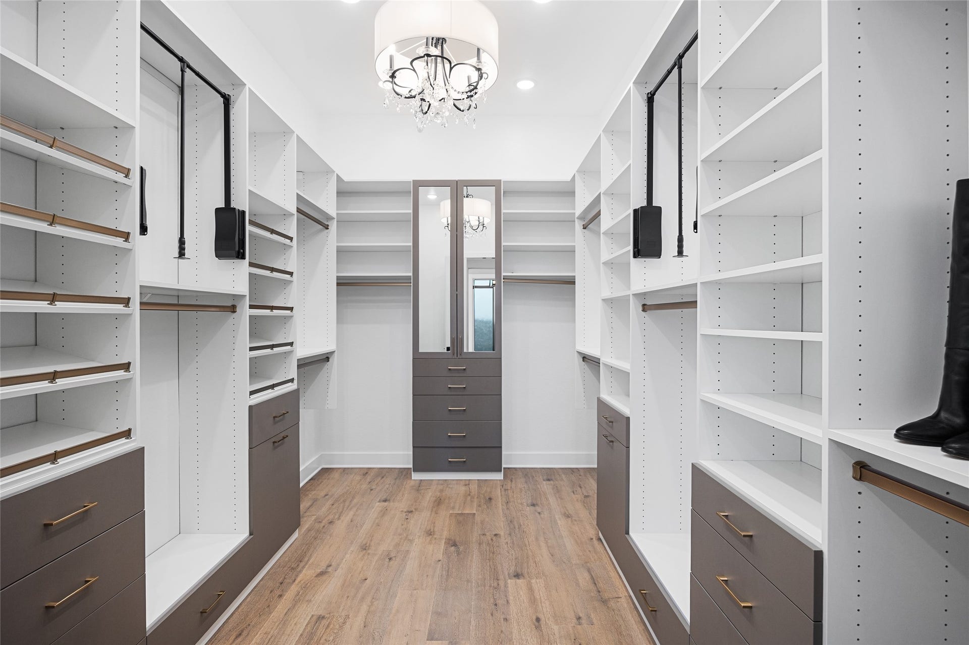 6707 Nimitz Court, Katy, TX 77493 Expansive custom California closet with built-in shelving, drawers, and hanging space, enhanced by a central island and statement lighting.