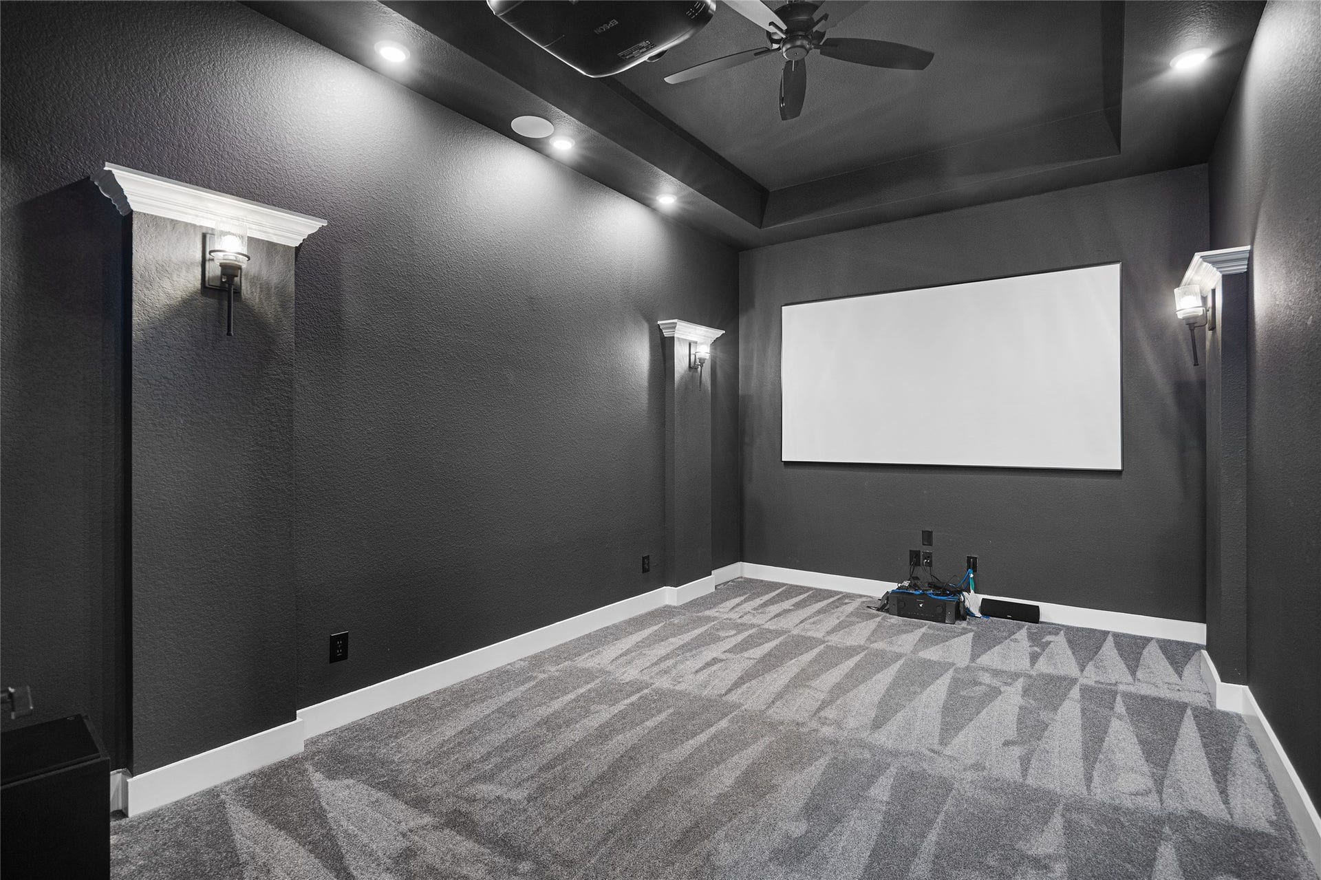 6707 Nimitz Court, Katy, TX 77493 Dedicated media room with tiered lighting, wall sconces, and projector, creating an ideal space for movie nights or game-day gatherings.