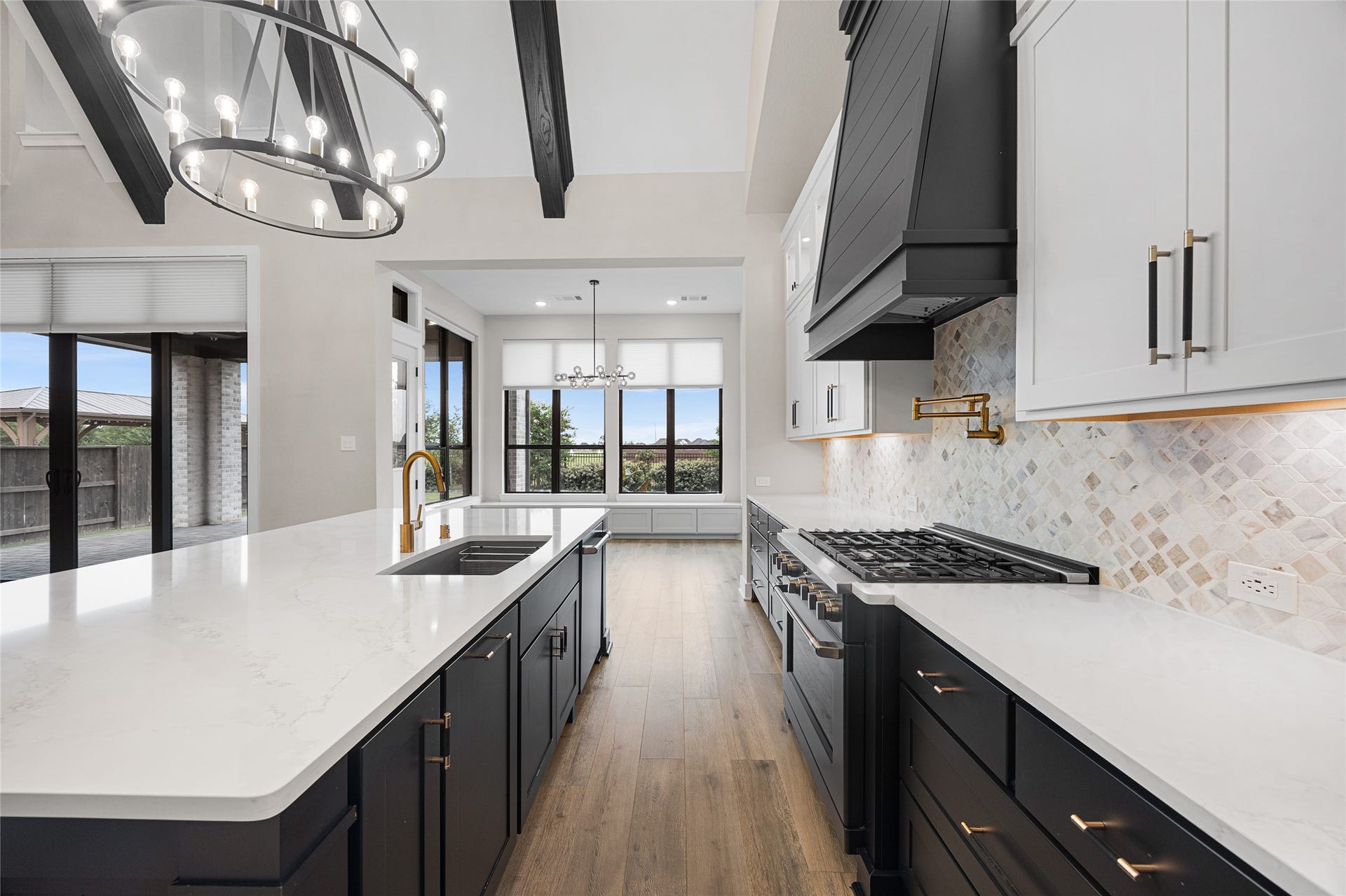 6707 Nimitz Court, Katy, TX 77493 Well-appointed cooking space featuring a Cafe appliances, professional-grade gas range, pot filler, and custom vent hood, all set against a textured tile backsplash.